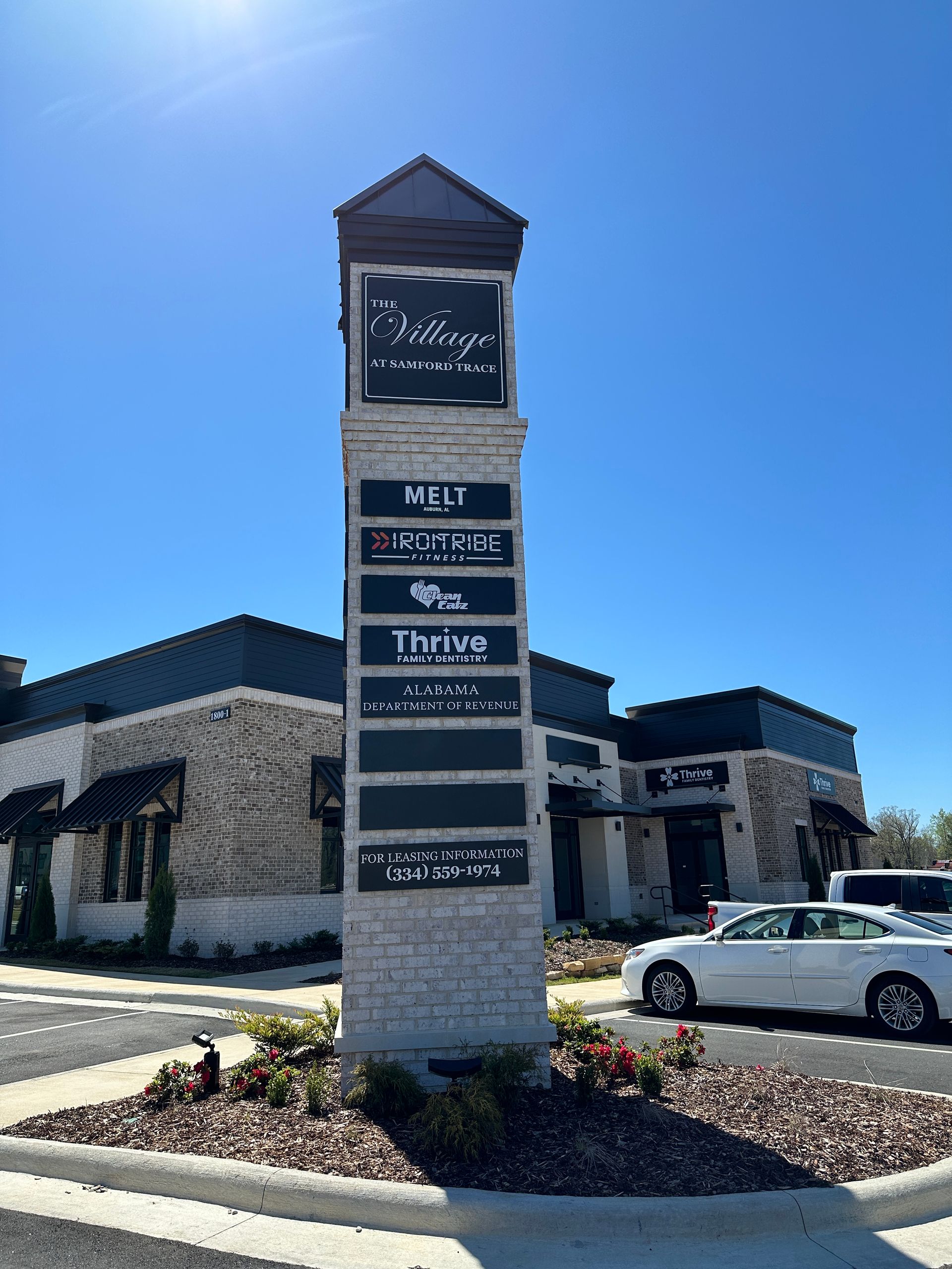 A large sign in front of a building with cars parked in front of it.