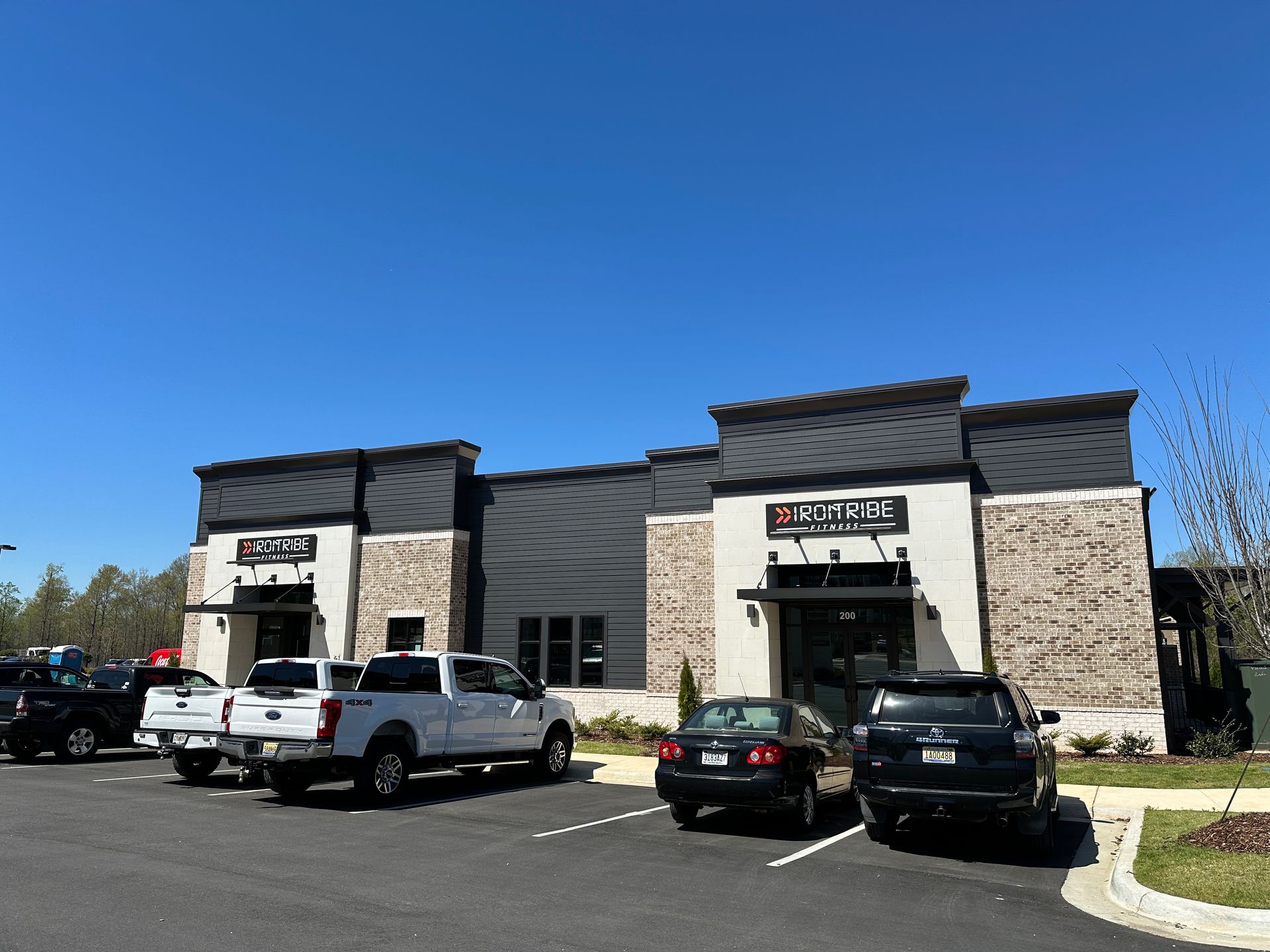 A lot of cars are parked in front of a building.