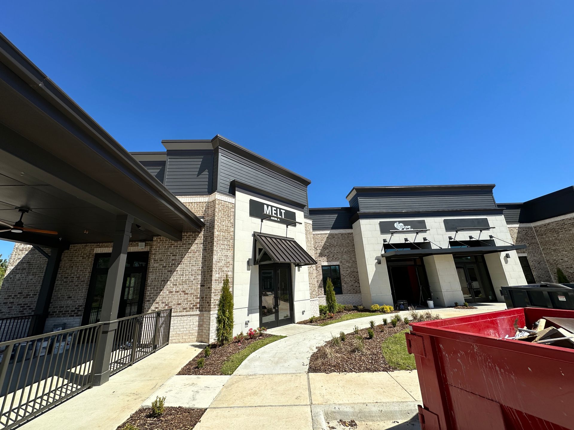 A large building with a red dumpster in front of it.