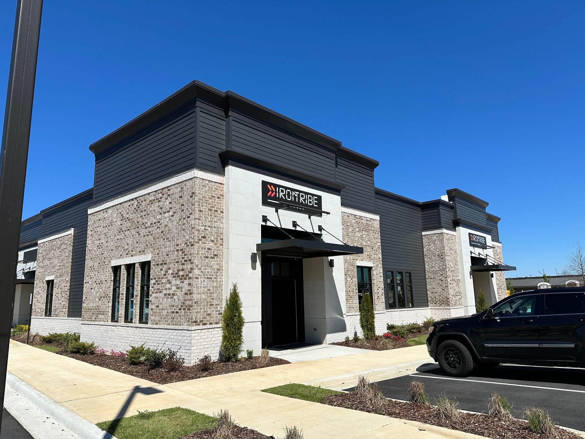 A car is parked in front of a large building.