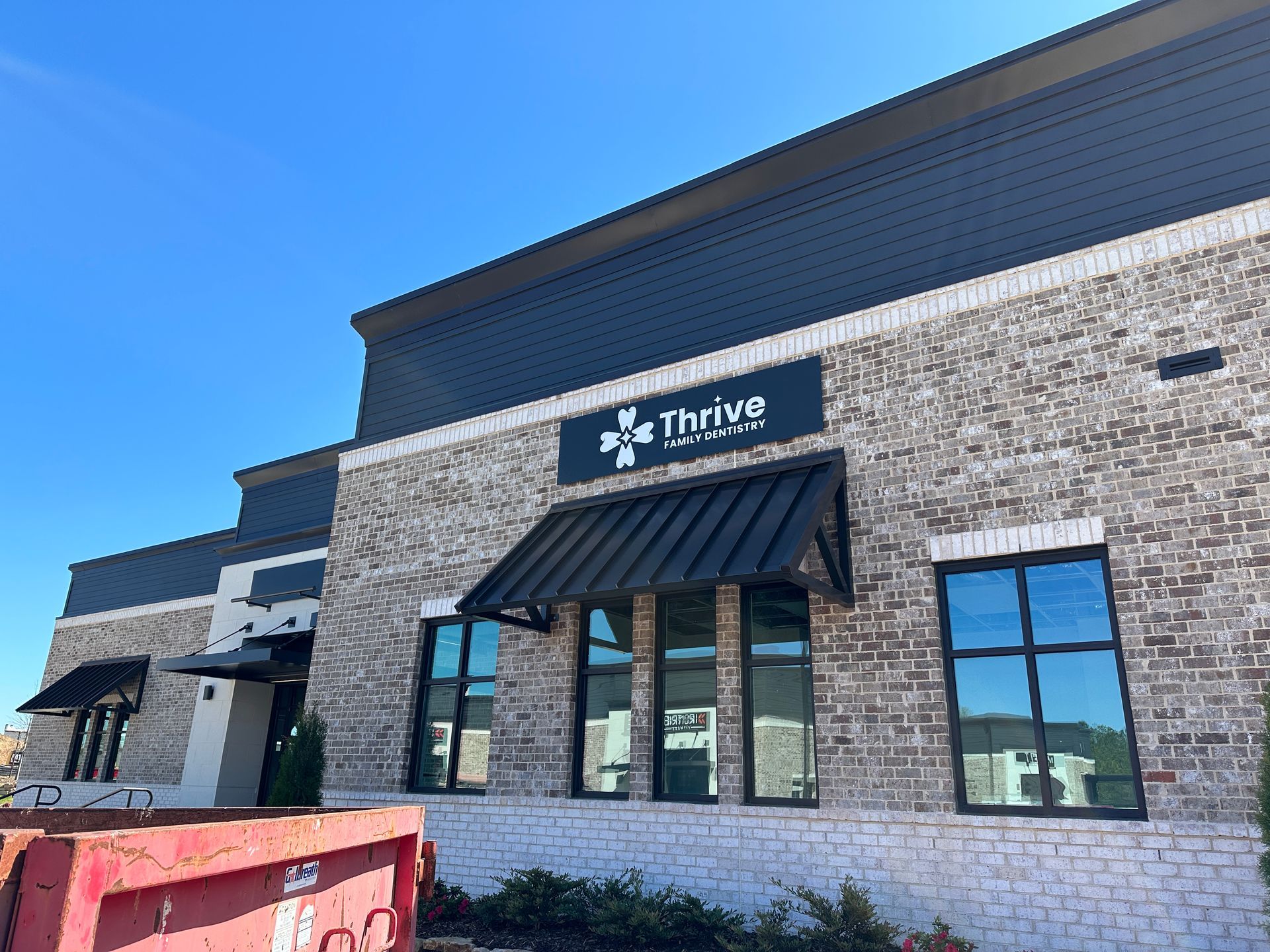 A brick building with a sign that says thrive on it