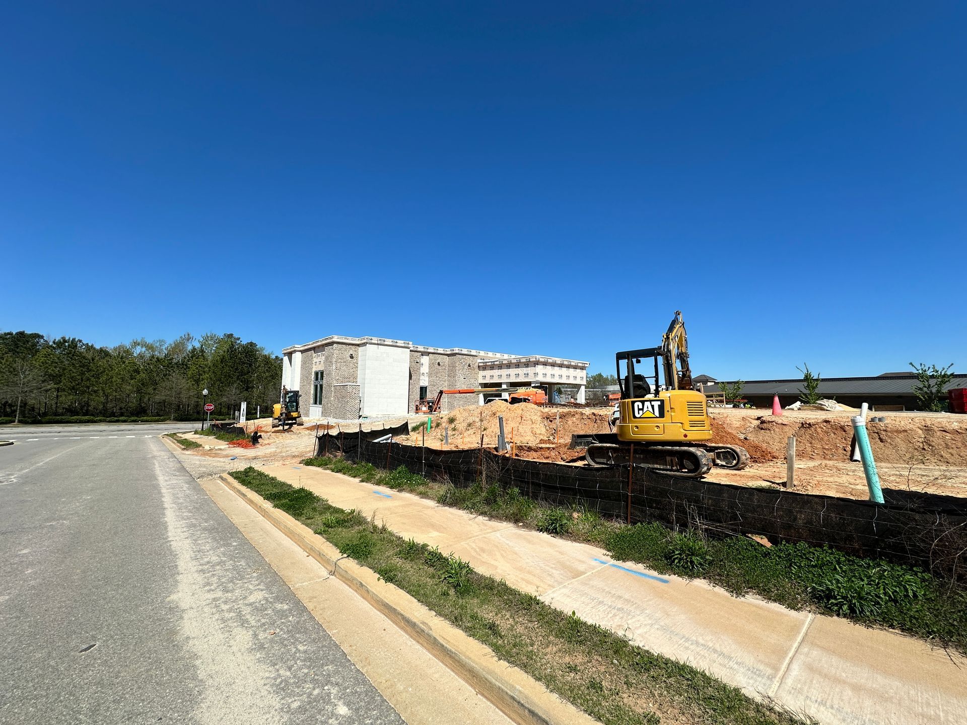 A yellow excavator is parked in front of a construction site.