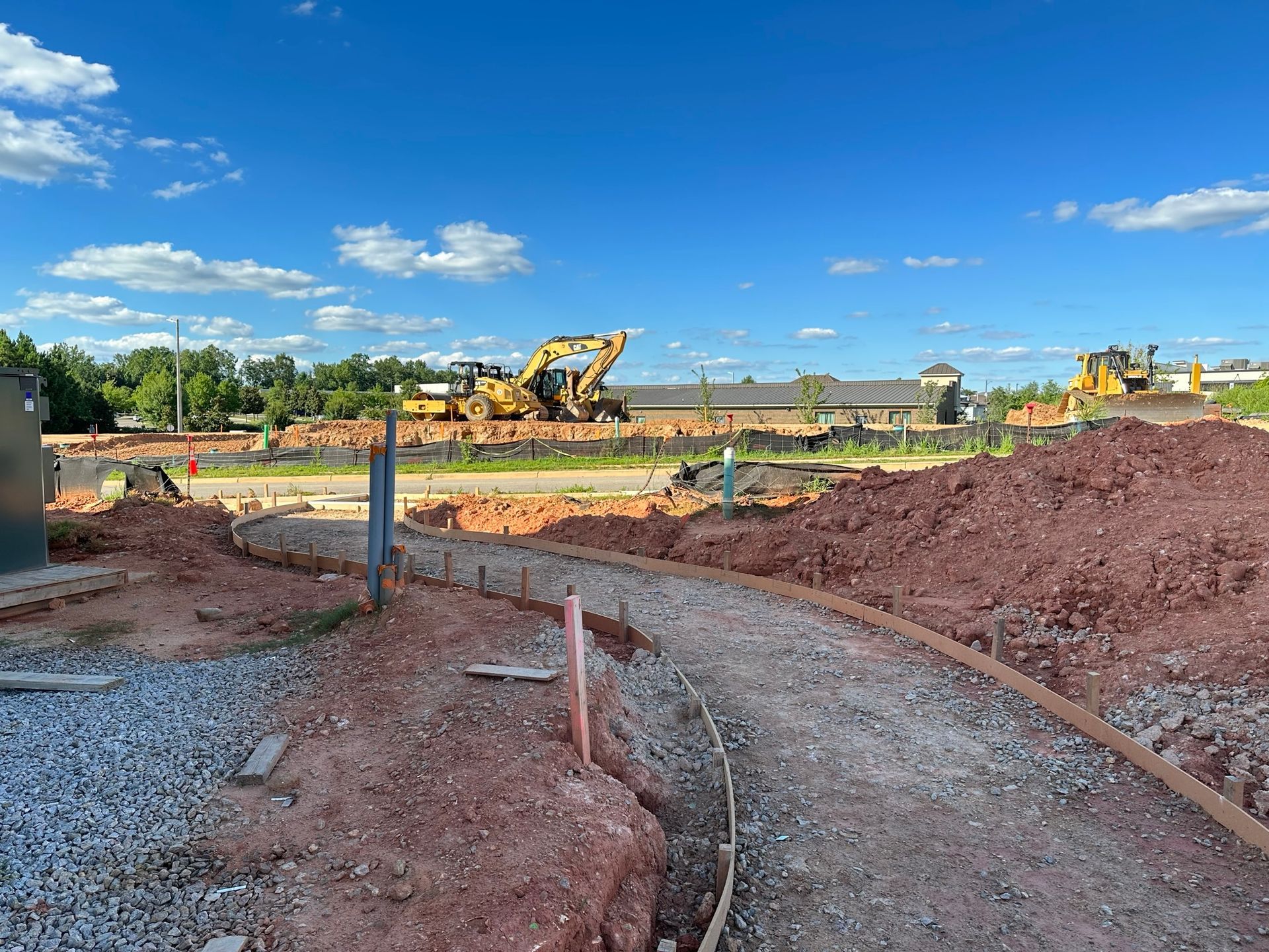 A construction site with a lot of dirt and trucks in the background.