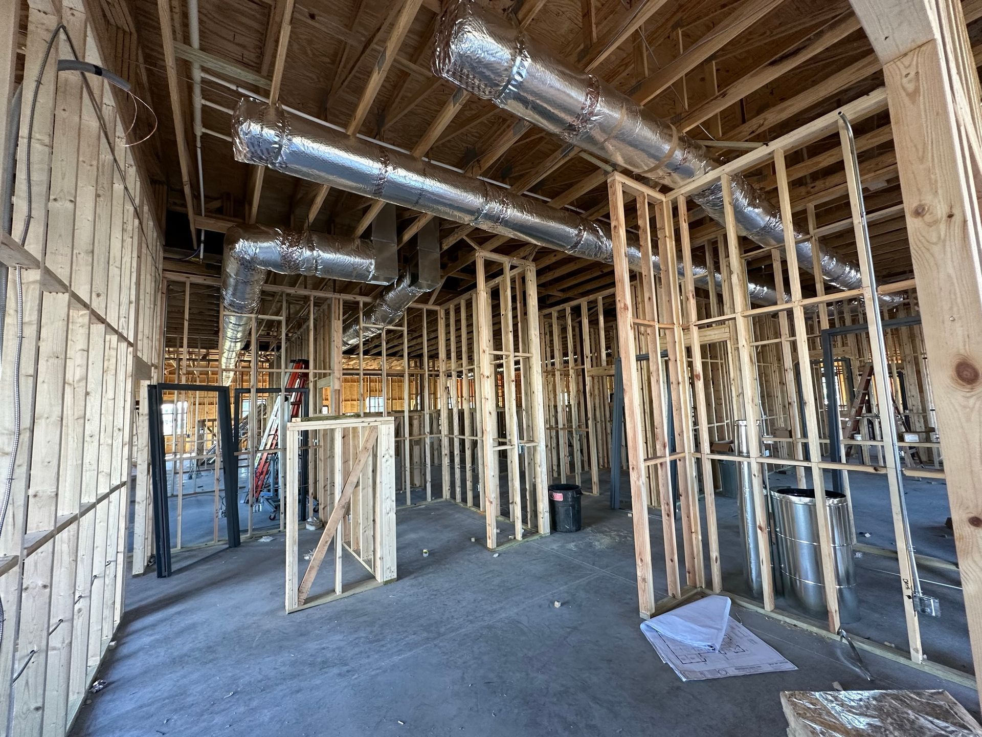 A building under construction with a lot of pipes coming out of the ceiling.