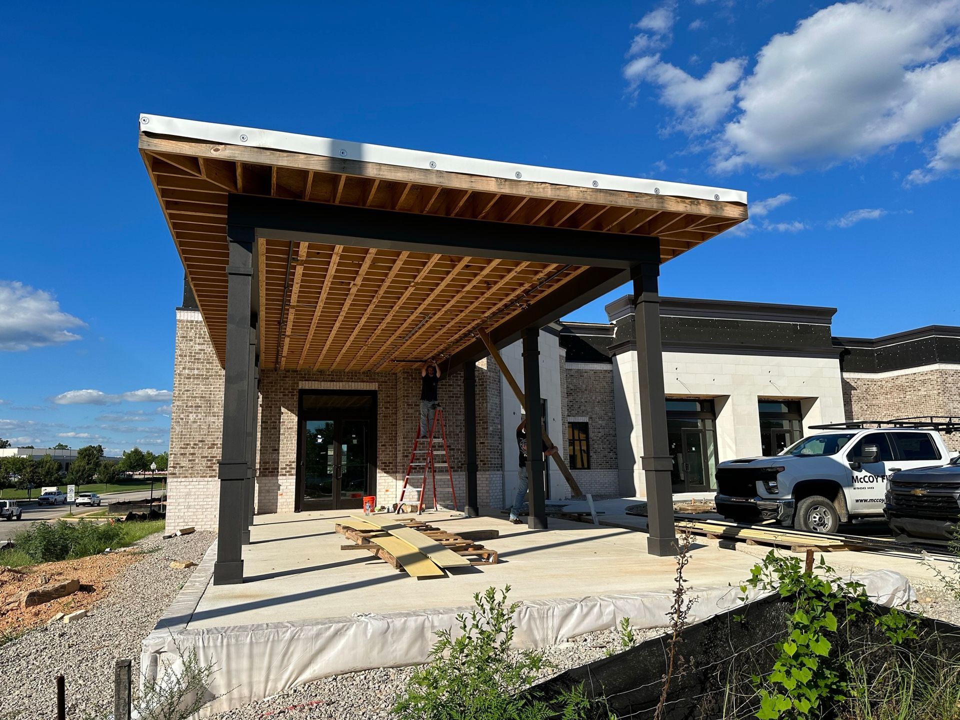 A truck is parked in front of a building under construction.