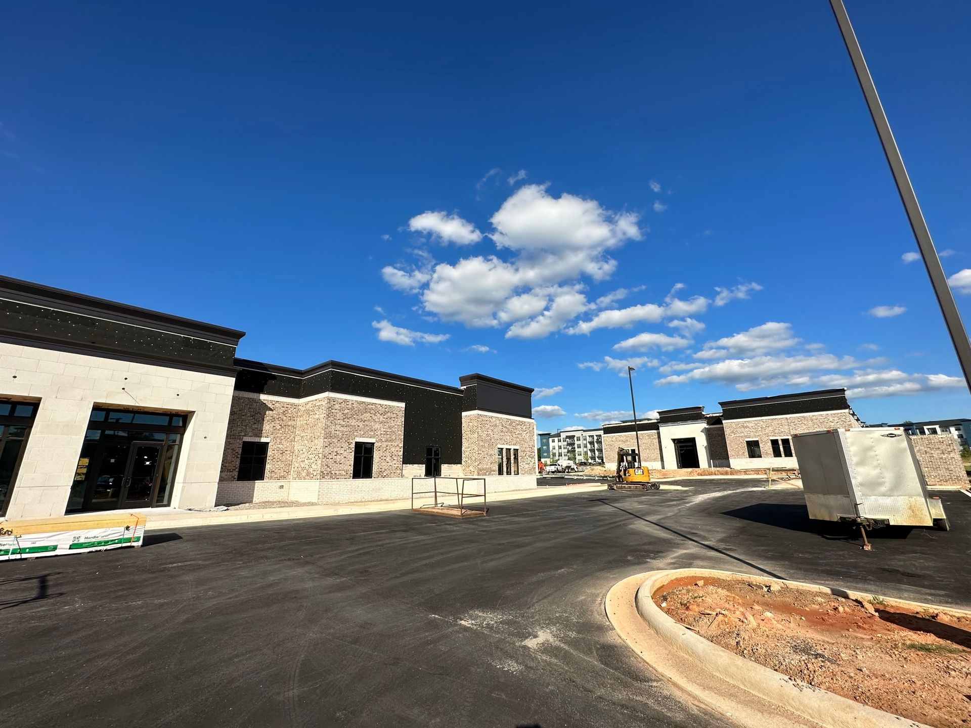 A building under construction with a blue sky and clouds in the background.