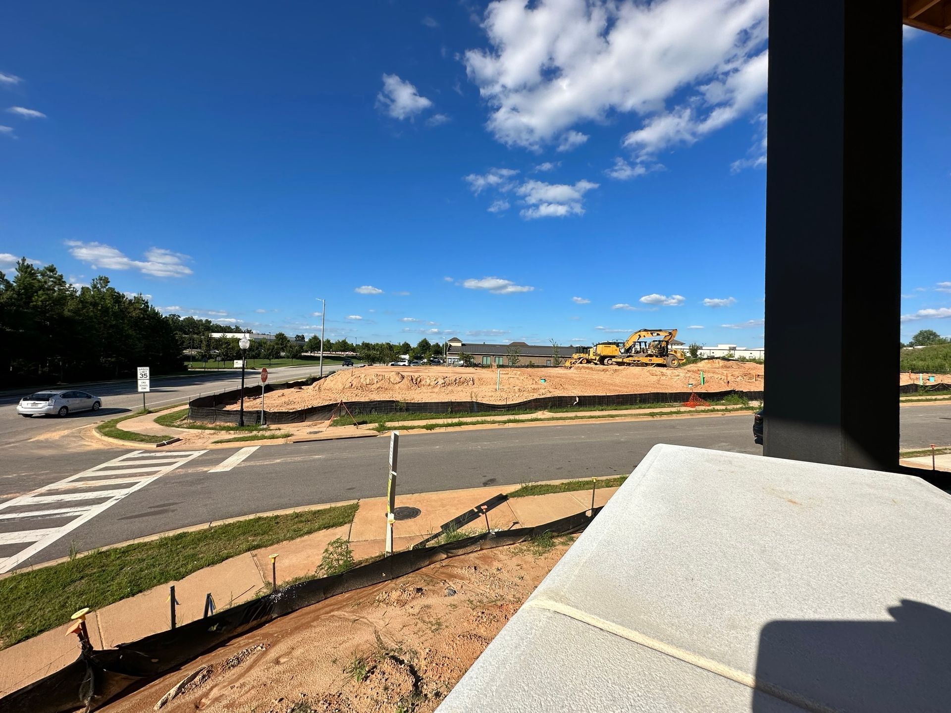 A view of a construction site from a balcony on a sunny day