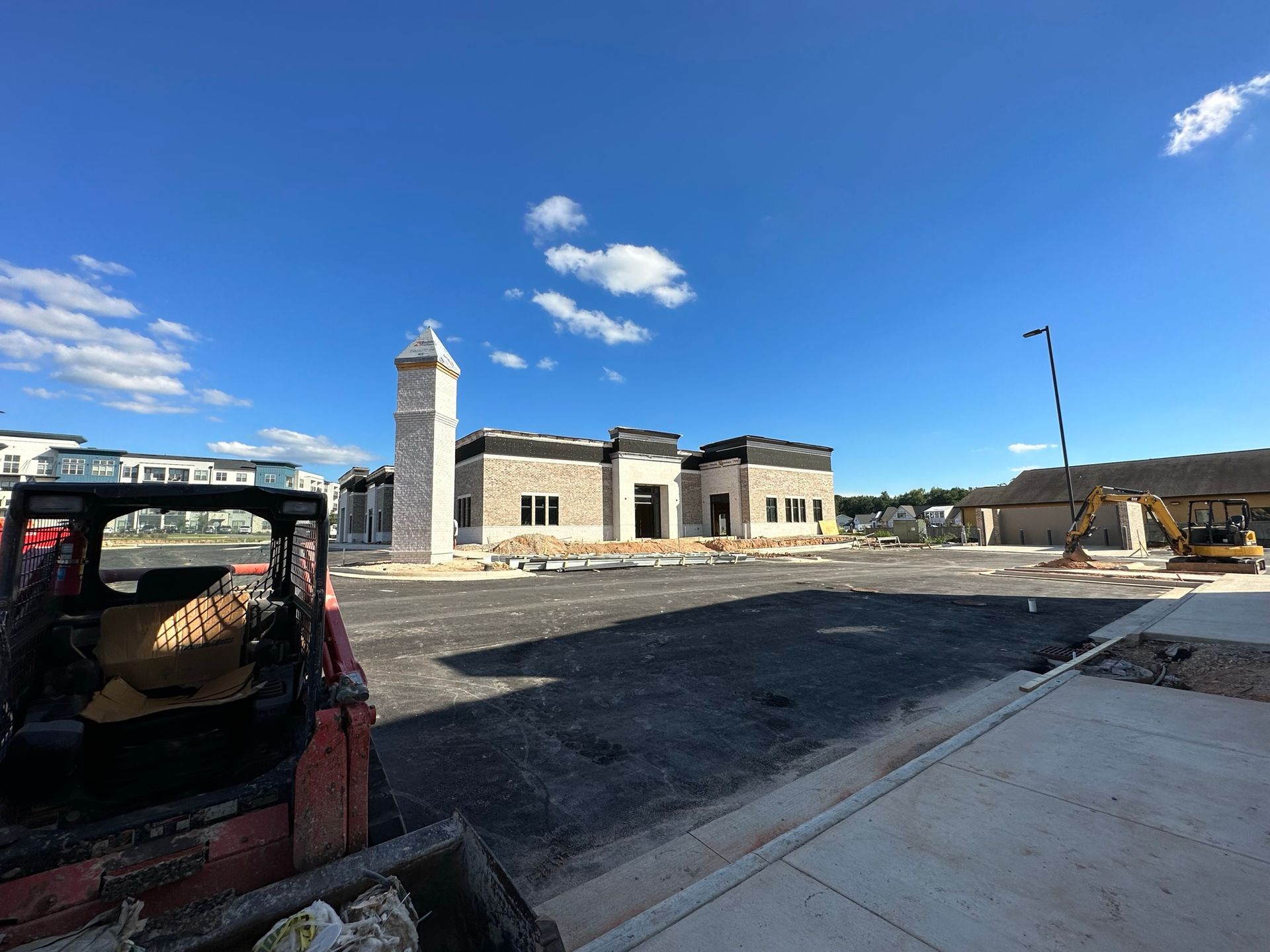 A bulldozer is parked in front of a building under construction.