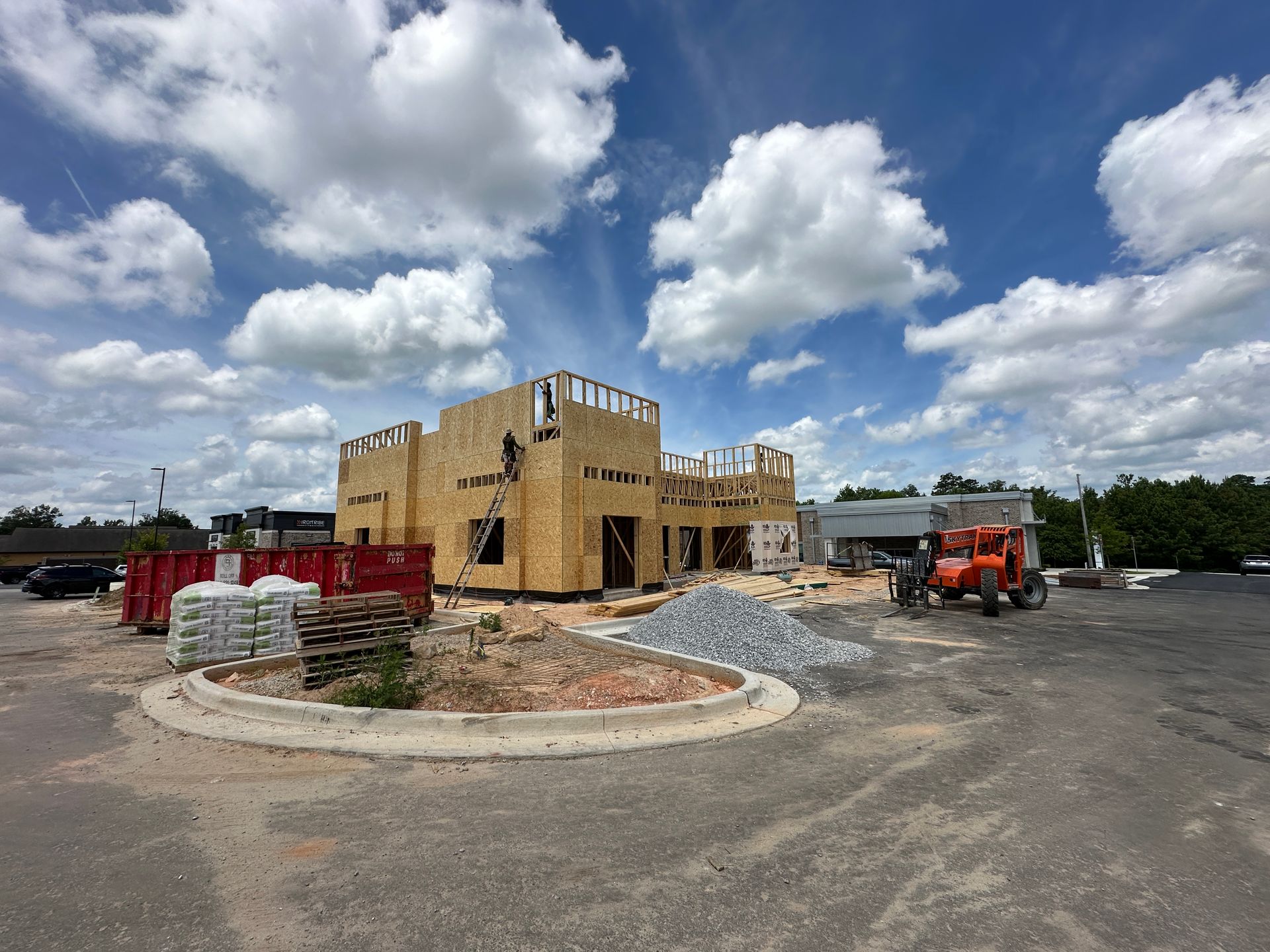 A large building is being built in a parking lot.