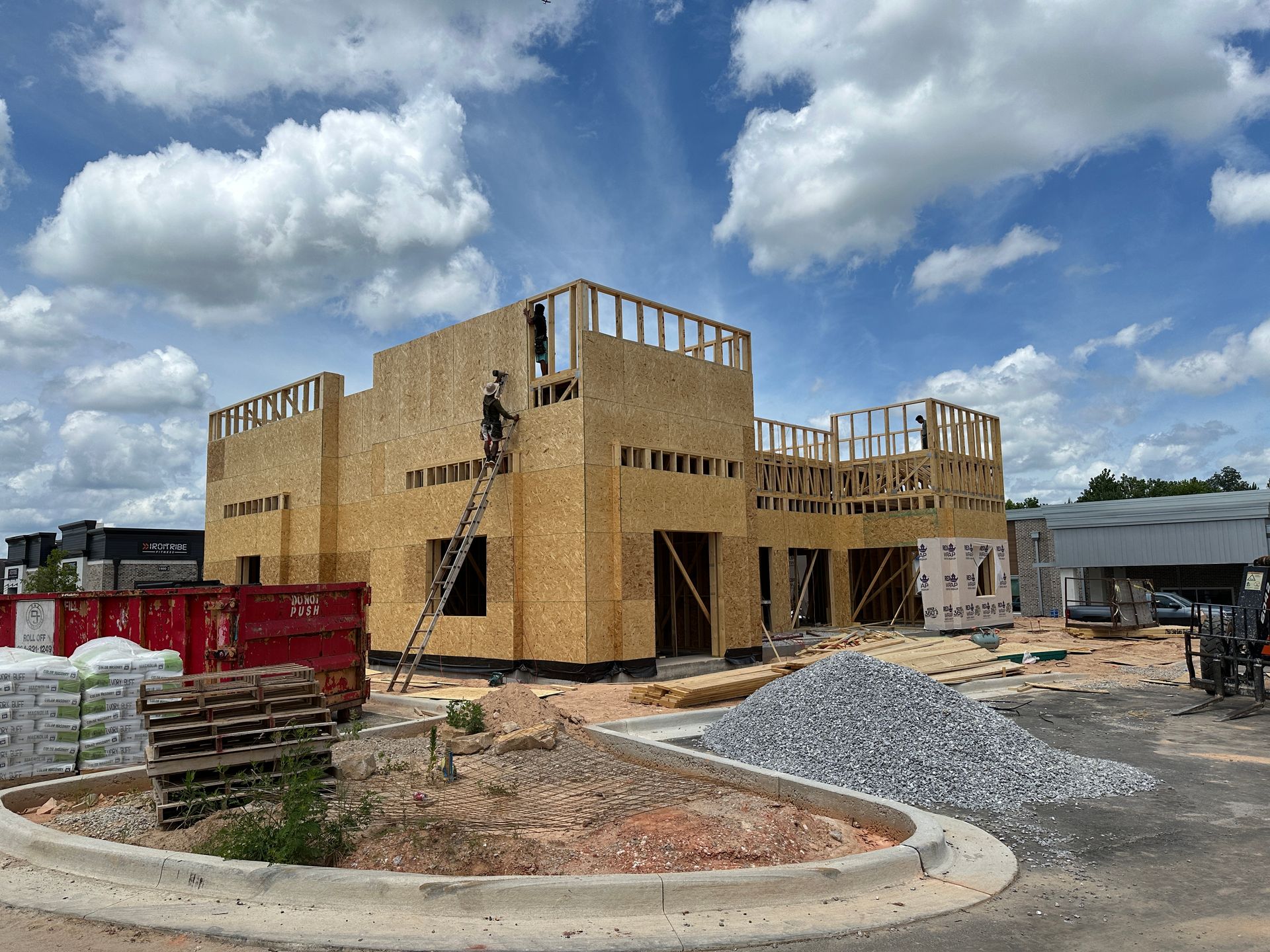 A large wooden building is being built on a sunny day.