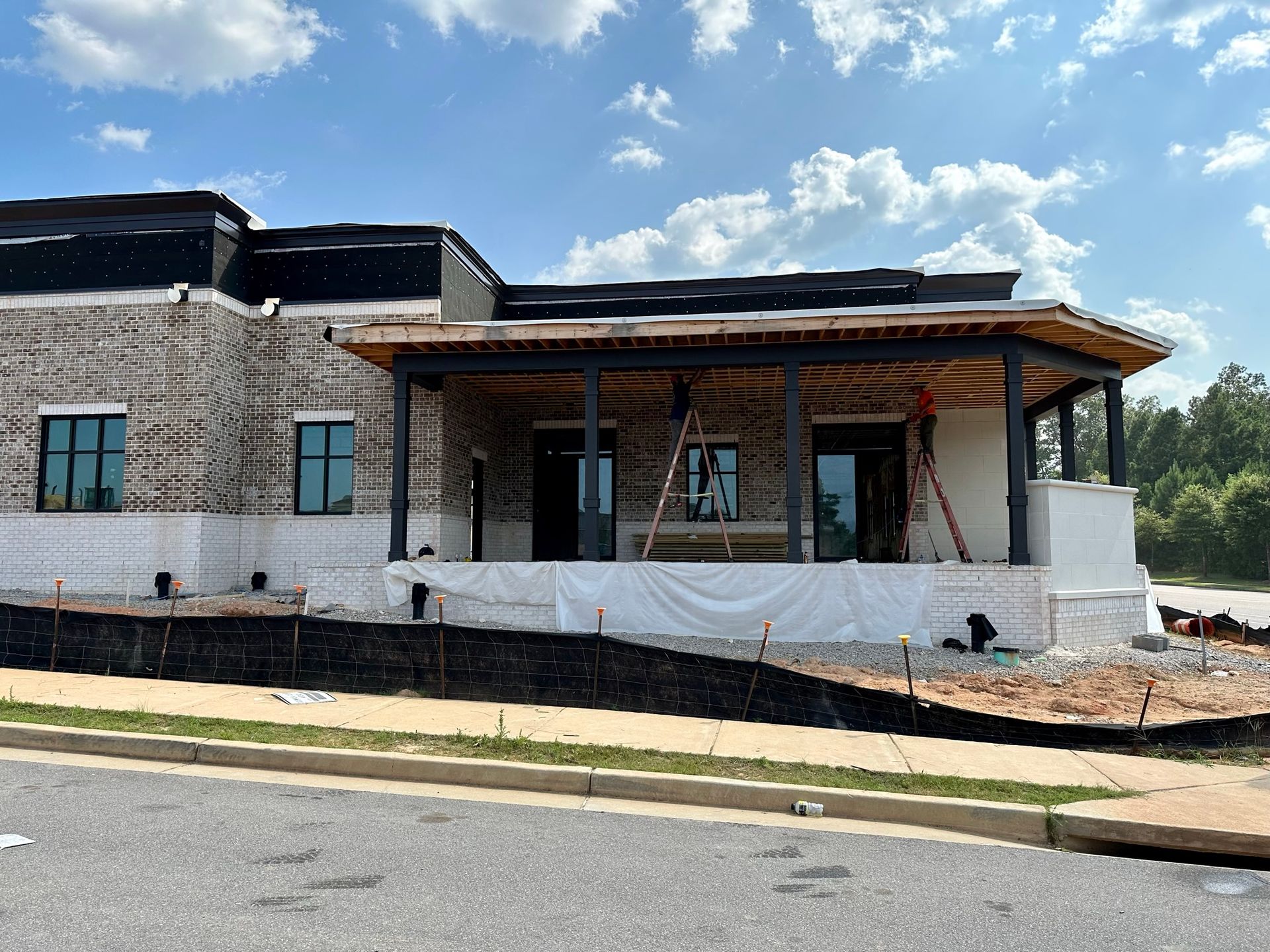 A large brick building with a porch is being built.