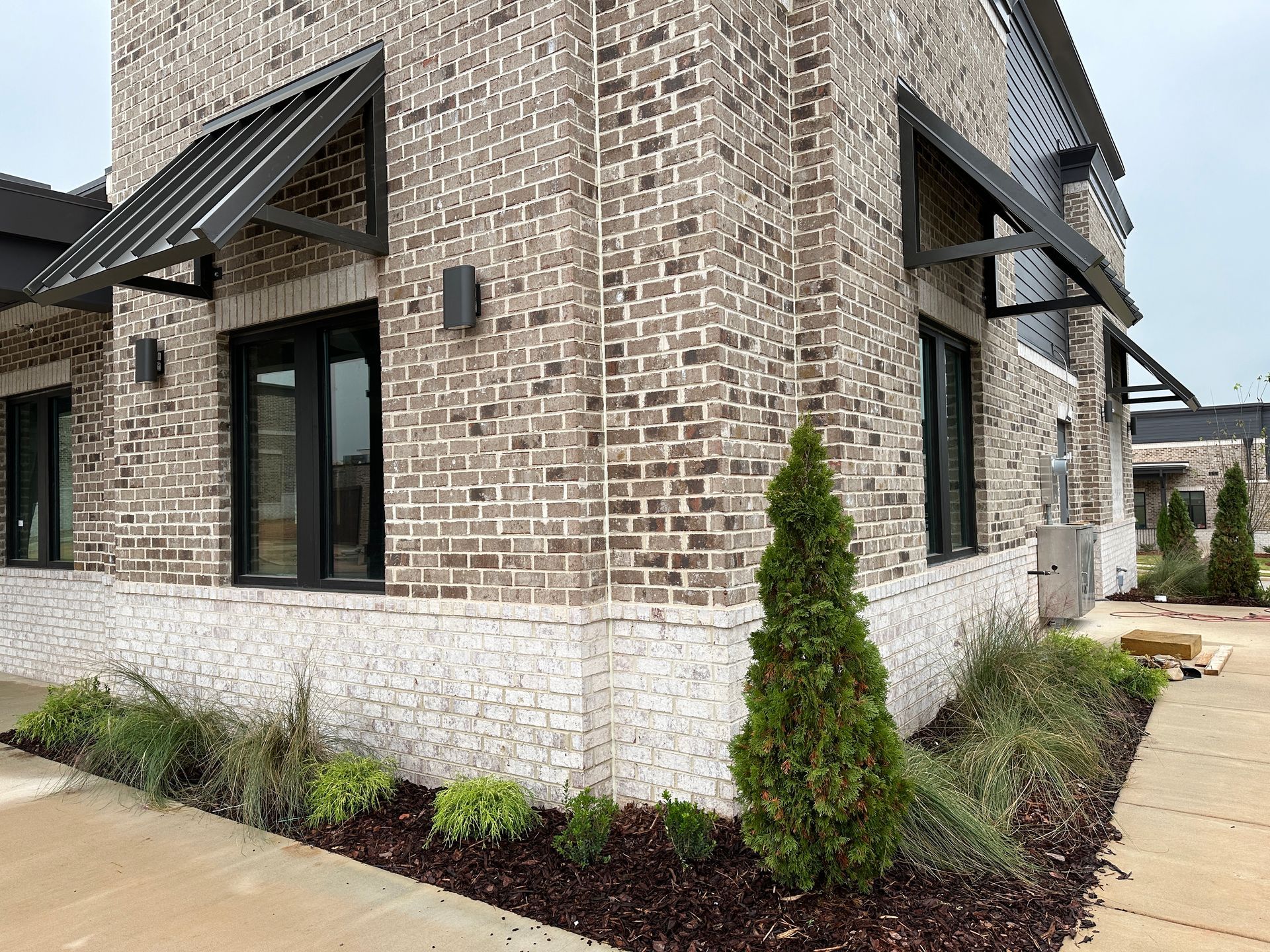 A brick building with a lot of windows and awnings on the side of it.