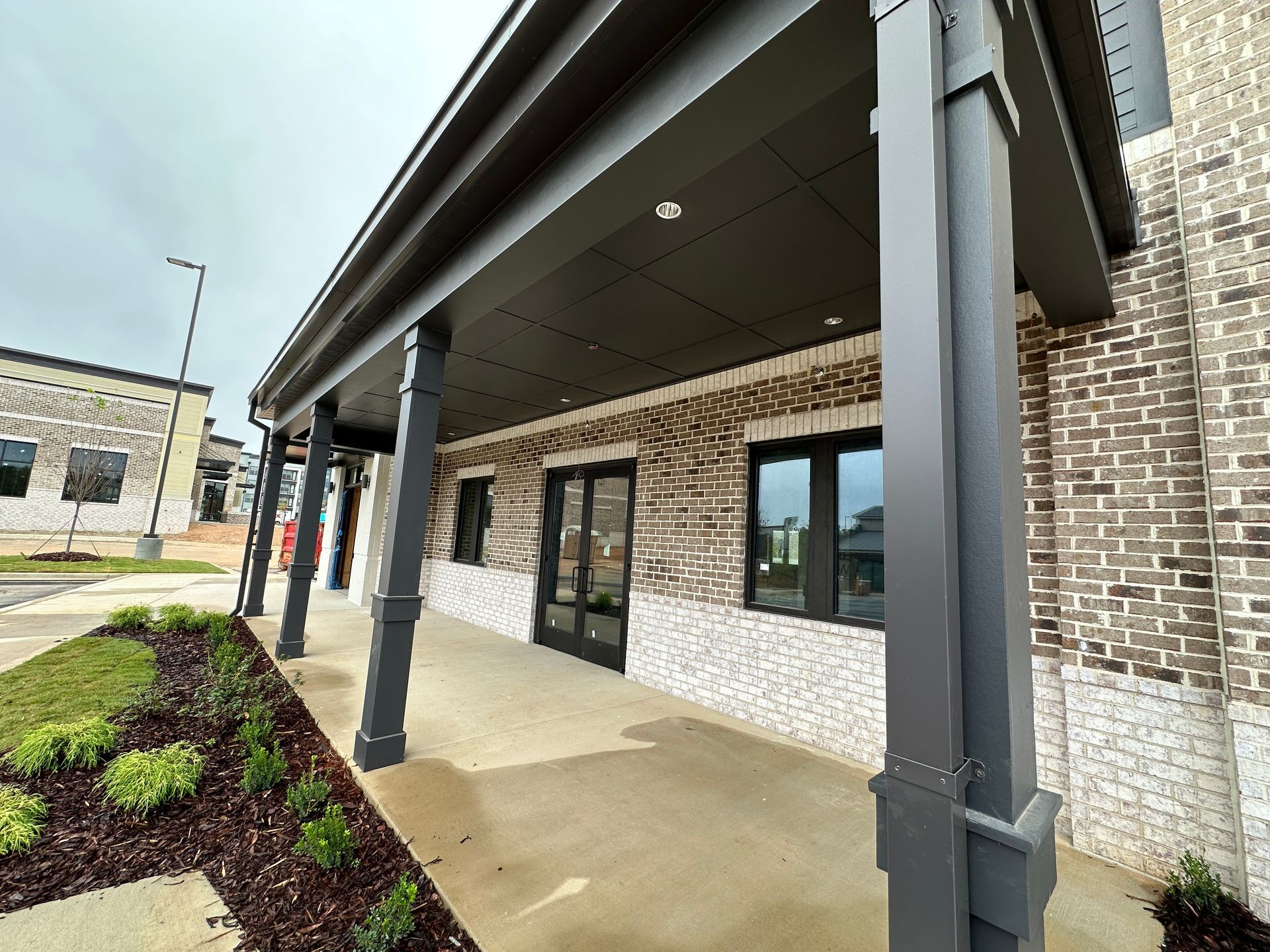 A building with a porch and a brick wall