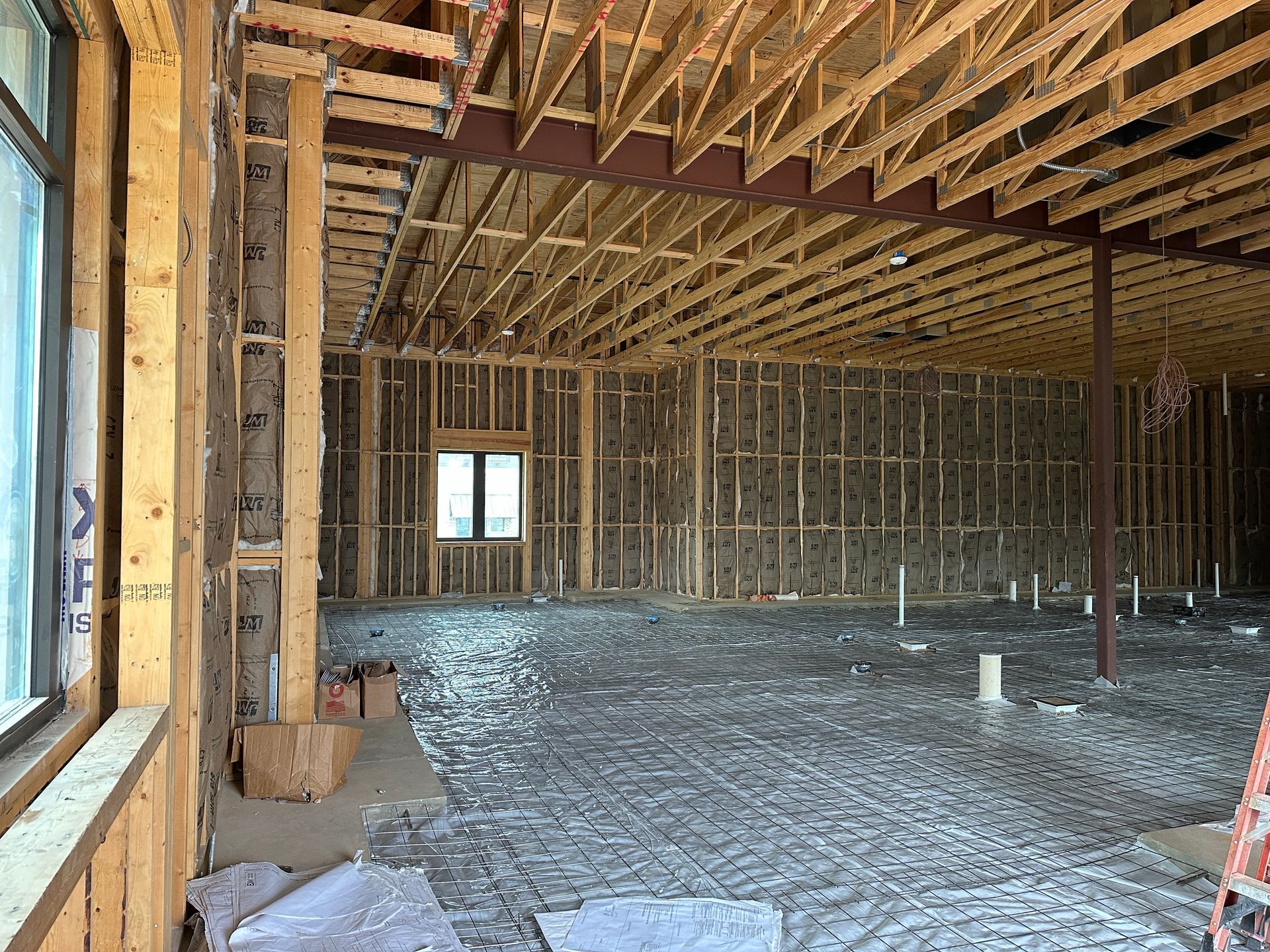The inside of a building under construction with a ladder in the background.