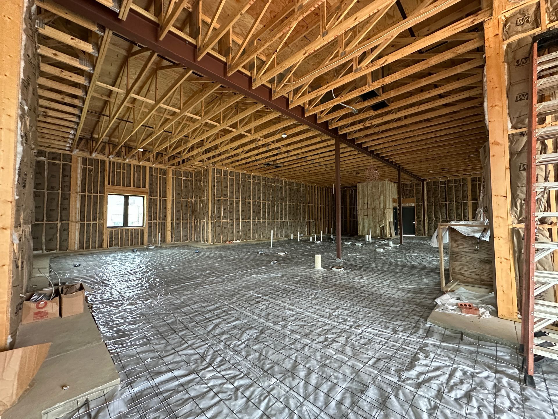 The inside of a building under construction with a lot of wooden beams.