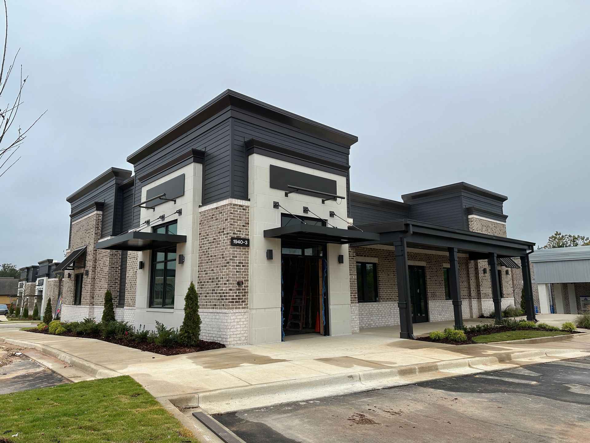 A large building with a lot of windows and a parking lot in front of it.