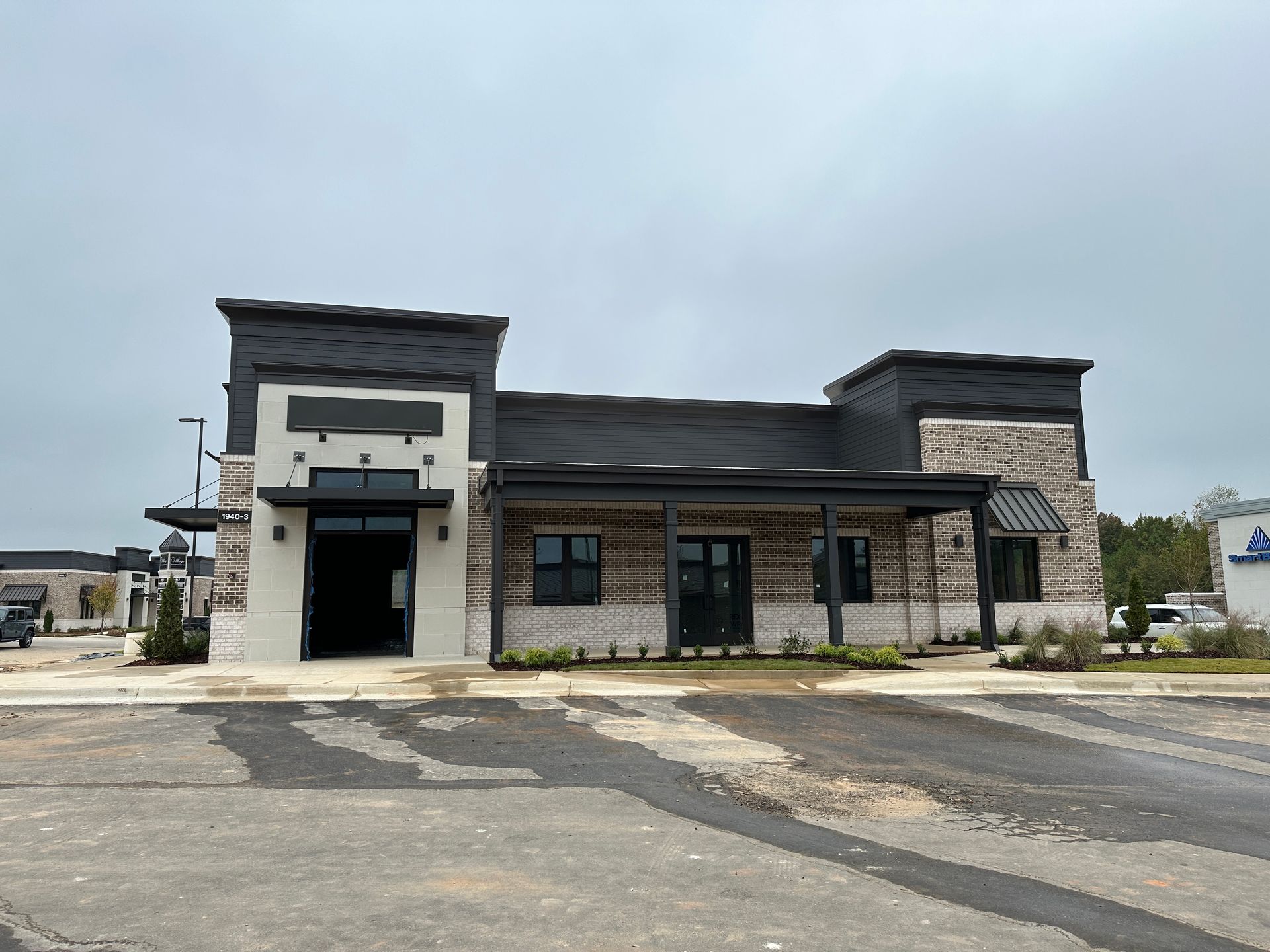 A large building with a lot of windows and a parking lot in front of it.