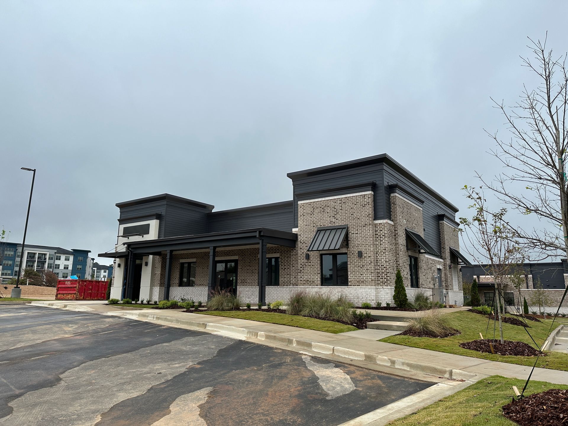 A large brick building with a parking lot in front of it.