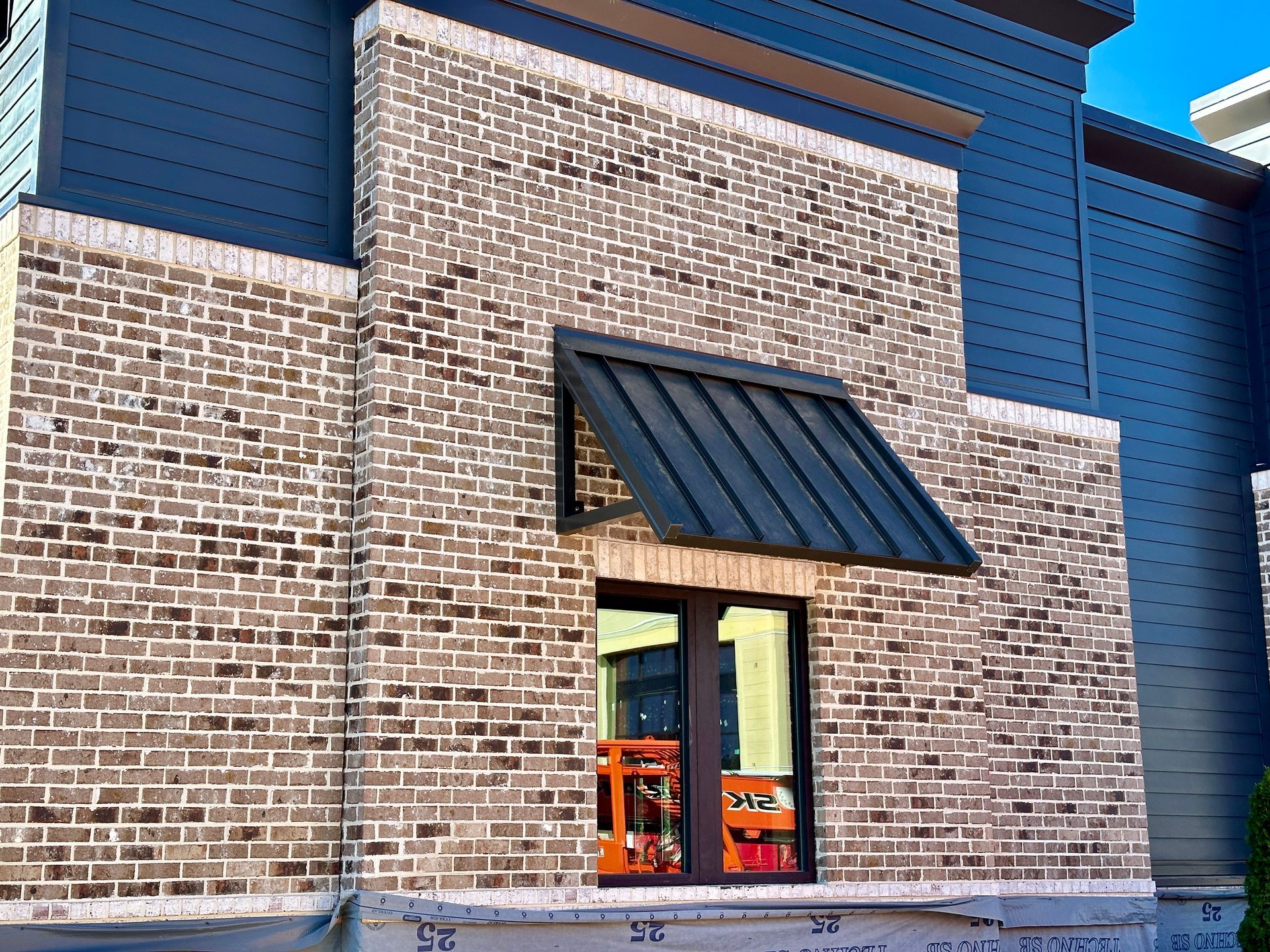 A brick building with a window and awning on it