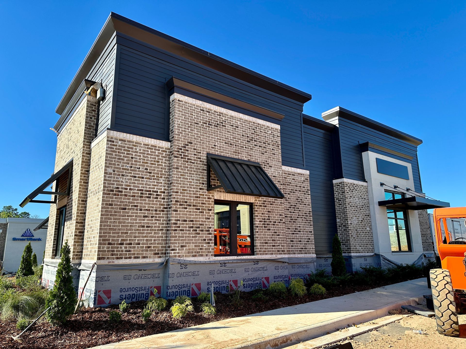 A large brick building with a black awning on the side of it.