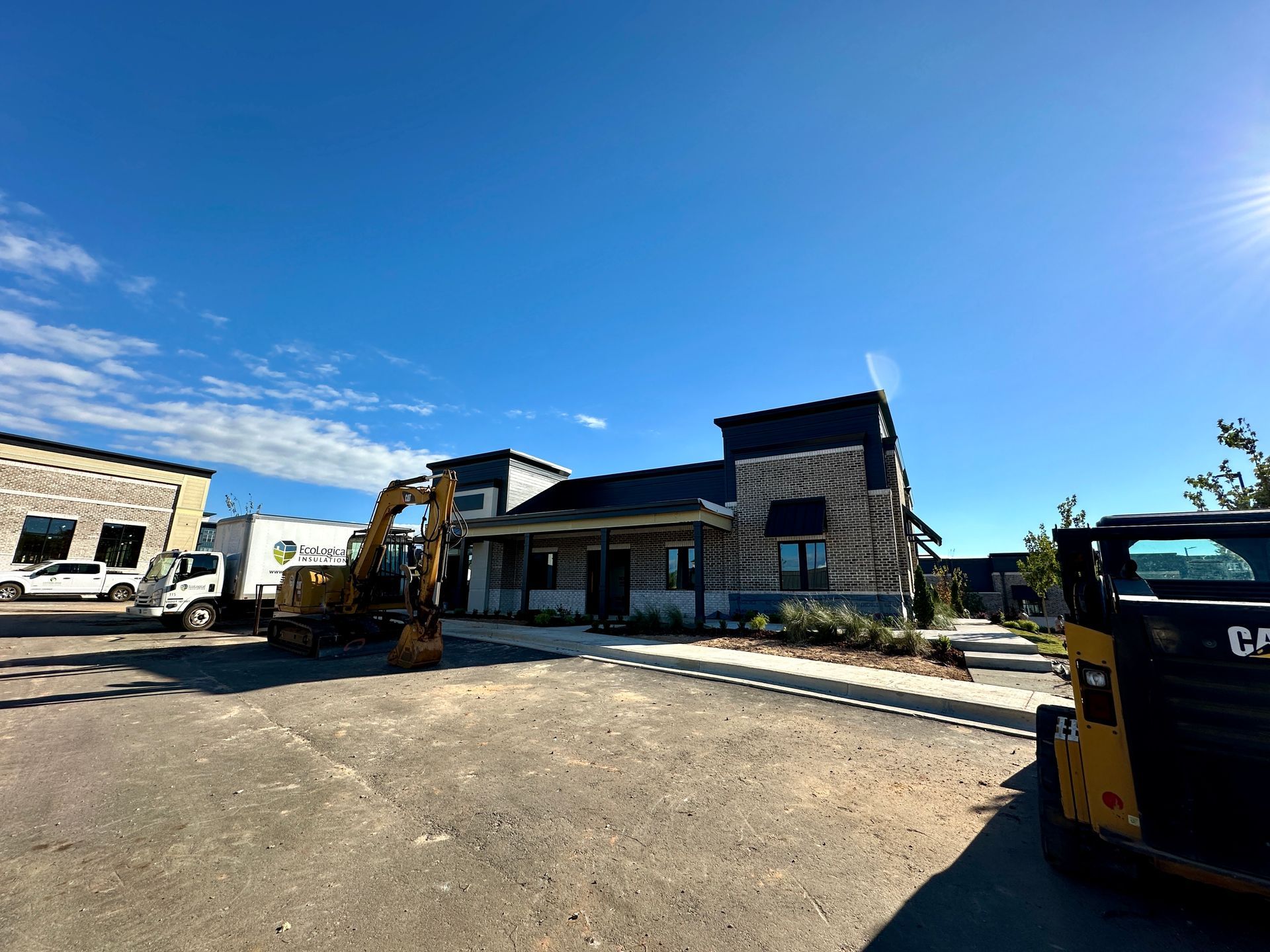 A construction vehicle is parked in front of a building under construction.