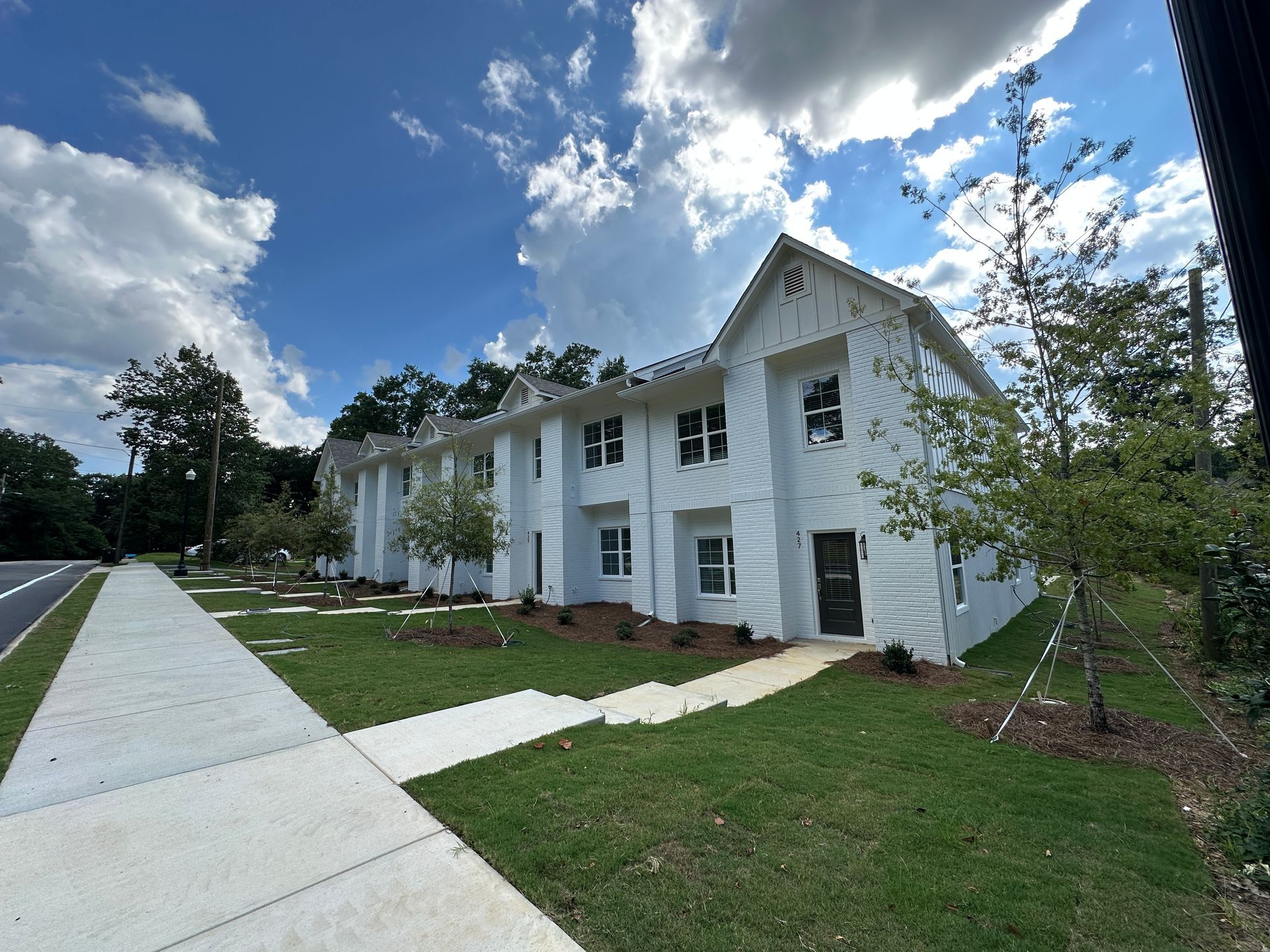An aerial view of a new Hovey Precast office building with a blue roof surrounded by trees.