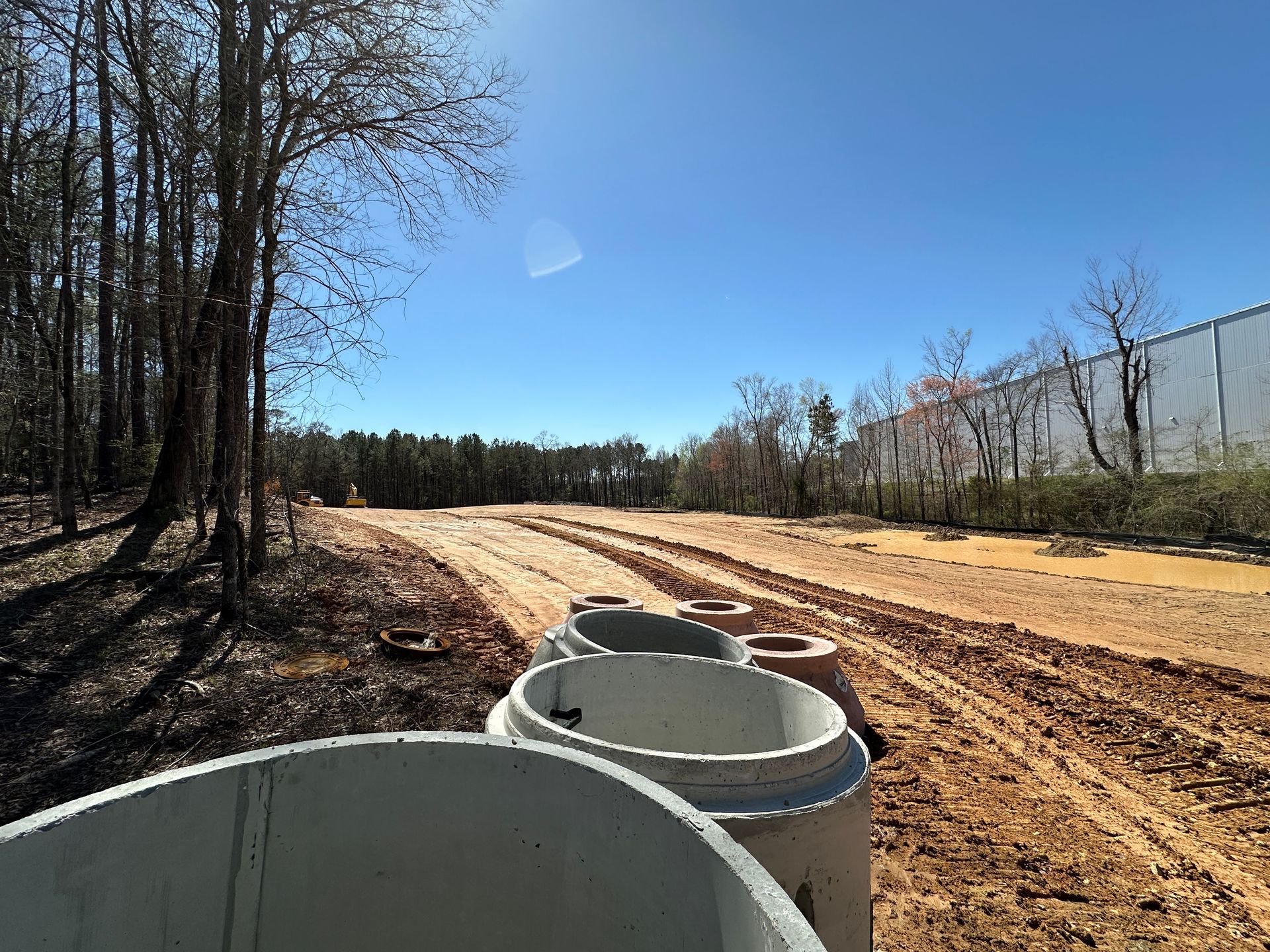 An aerial view of a new Hovey Precast office building with a blue roof surrounded by trees.