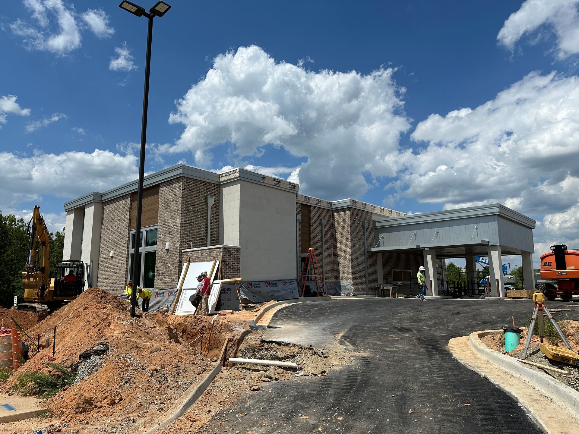 A large building under construction with a lot of dirt in front of it.