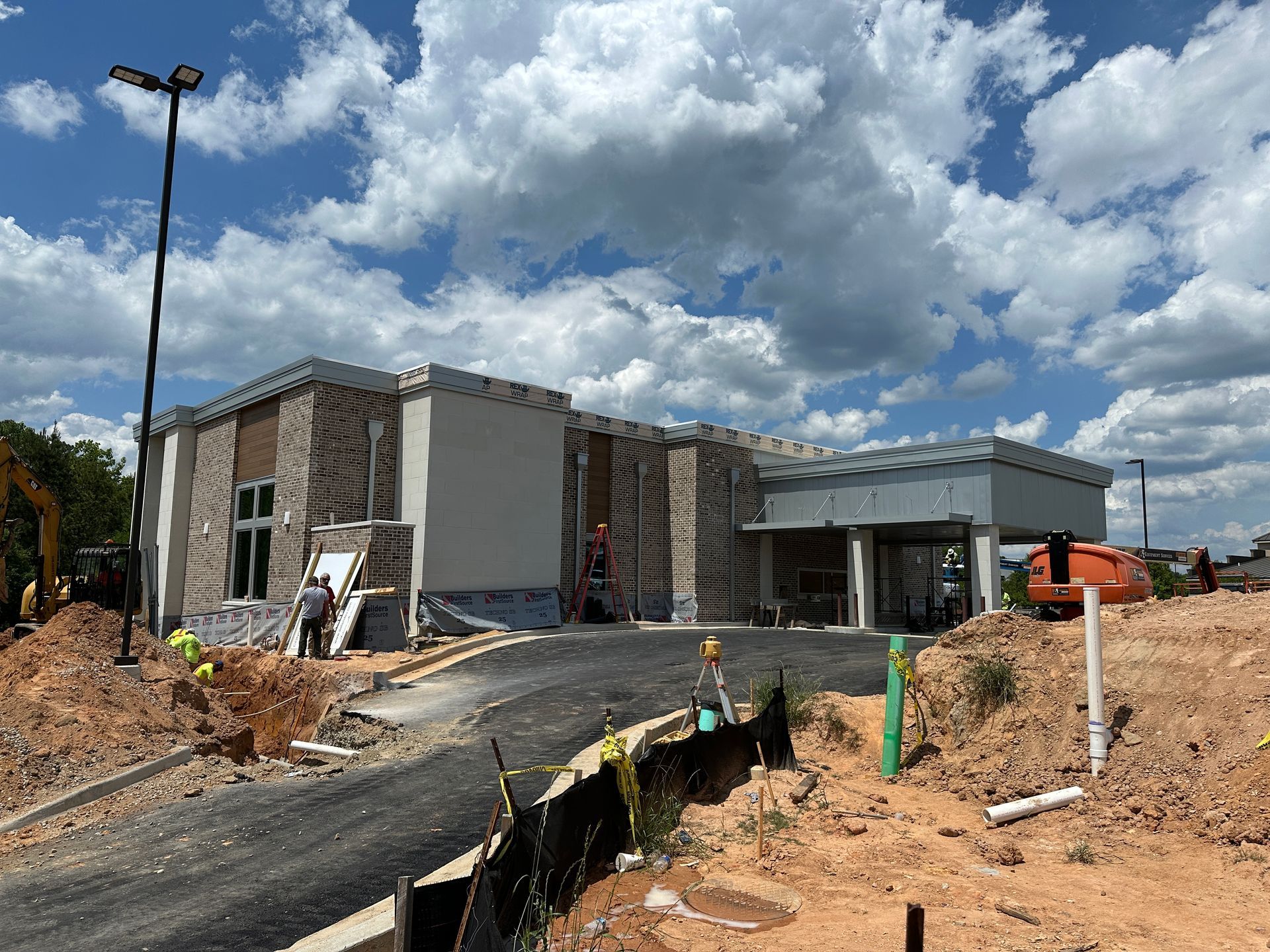 A large building is being built in the middle of a dirt field.