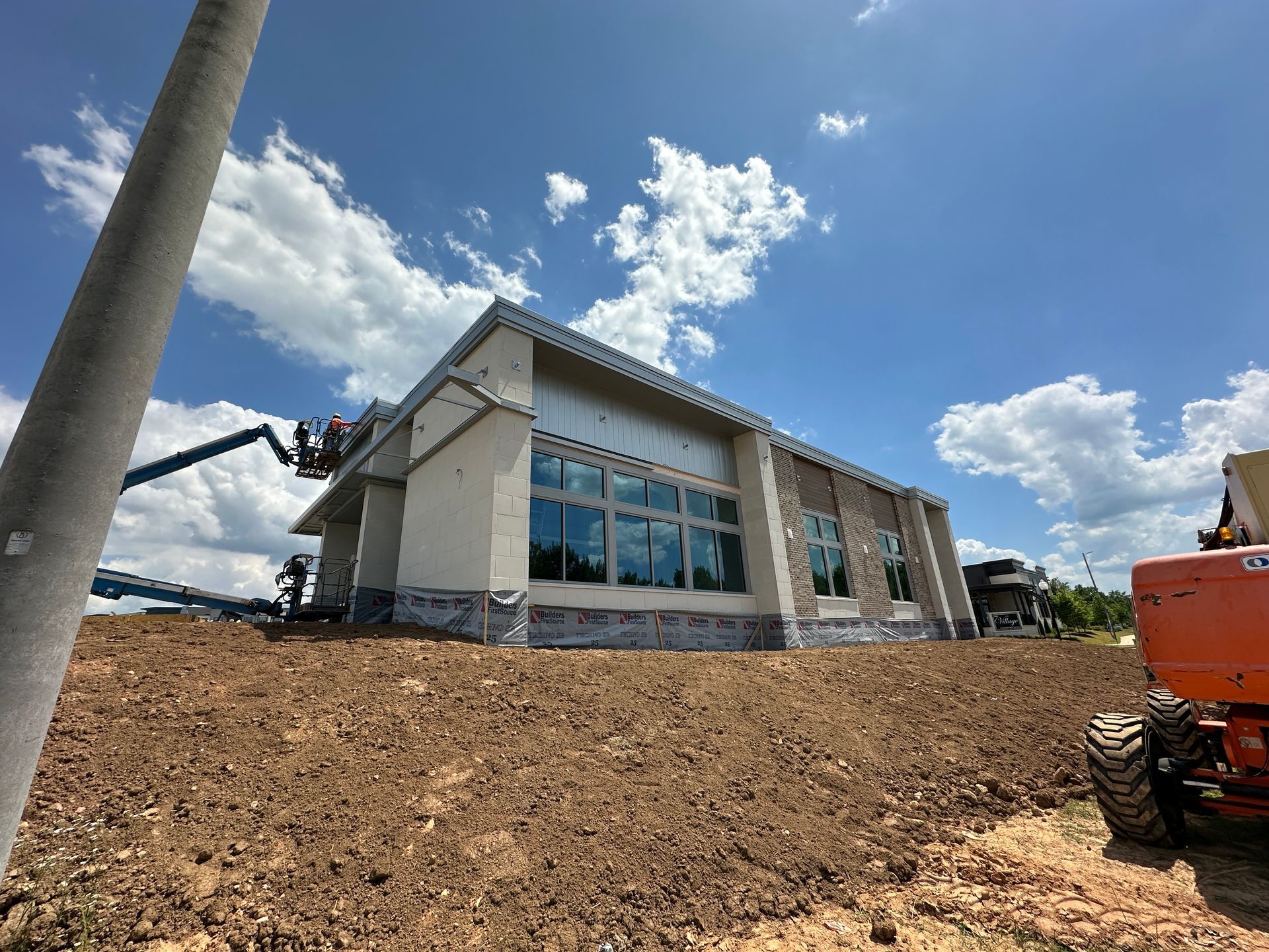 A large building is being built on top of a dirt hill.