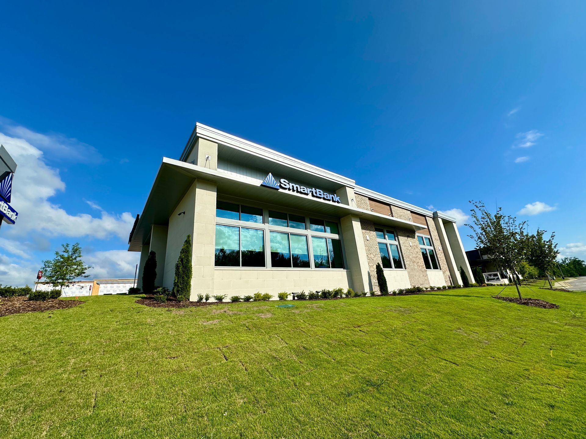 A large building with a lot of windows is sitting on top of a lush green hill.