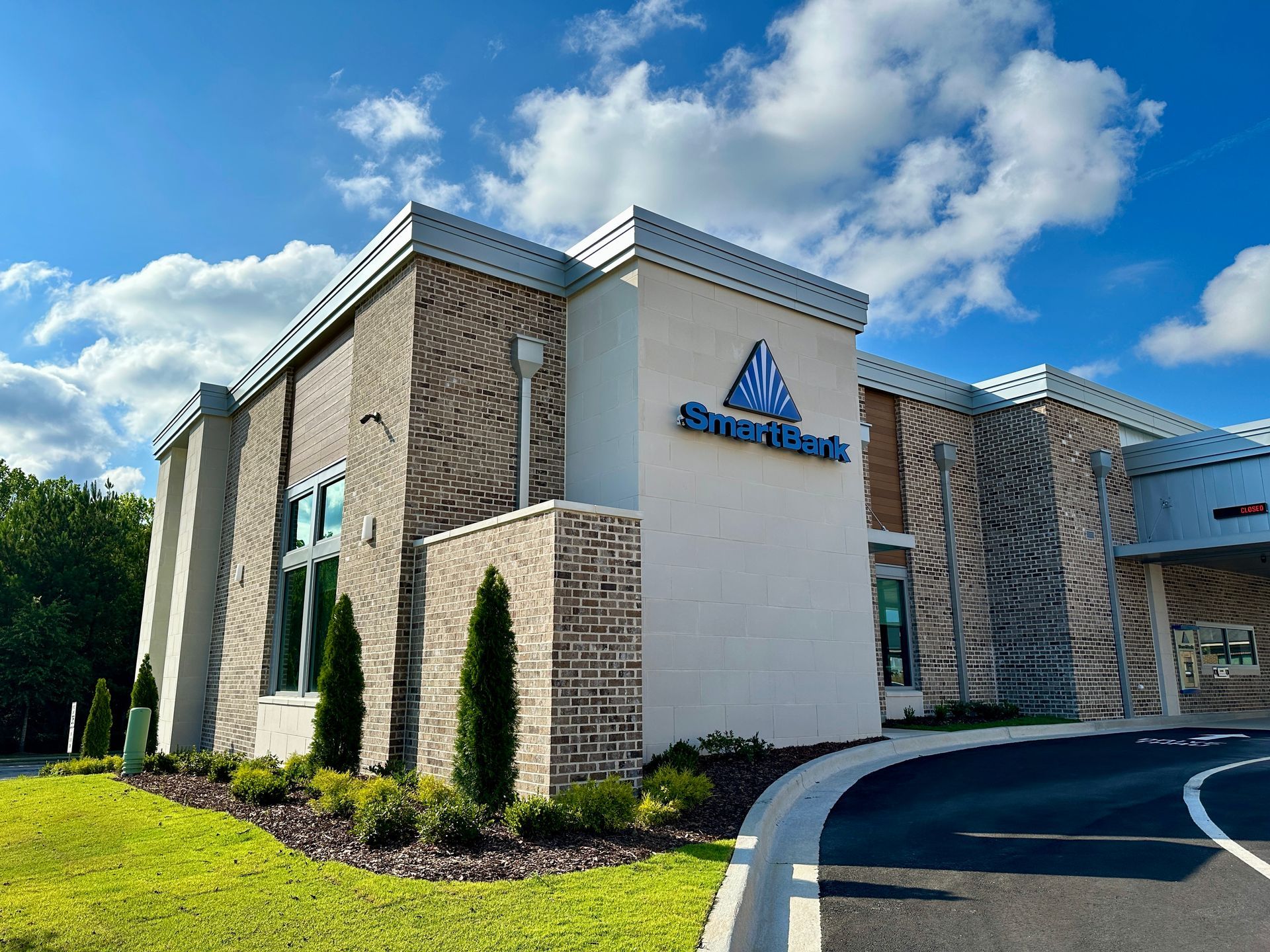 A large white bank building with a blue sign on the side of it.
