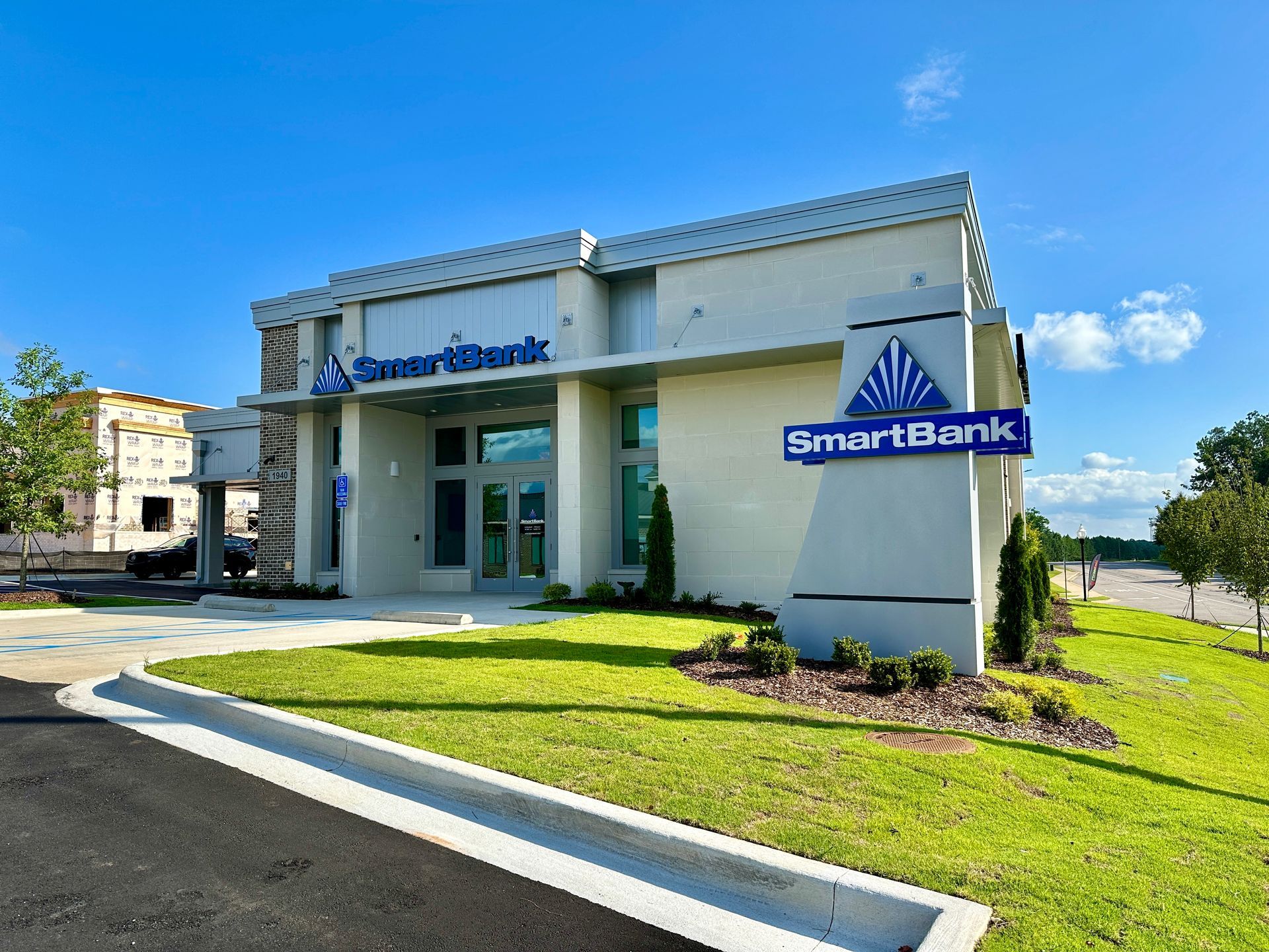 A smart bank building with a lot of grass in front of it.