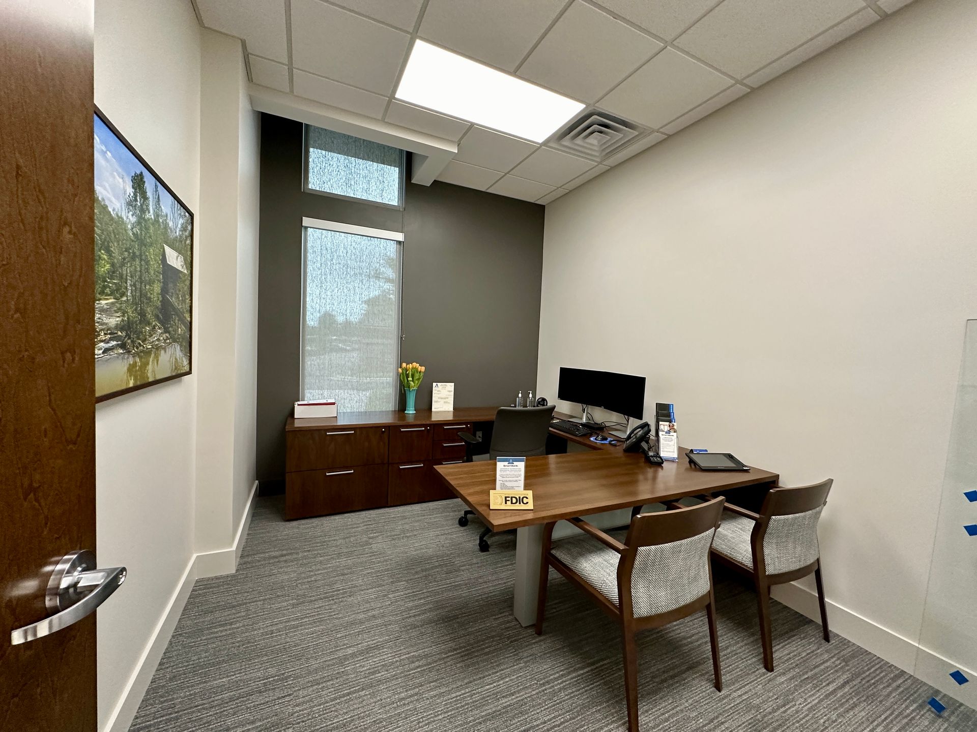 A small office with a desk and chairs in it.