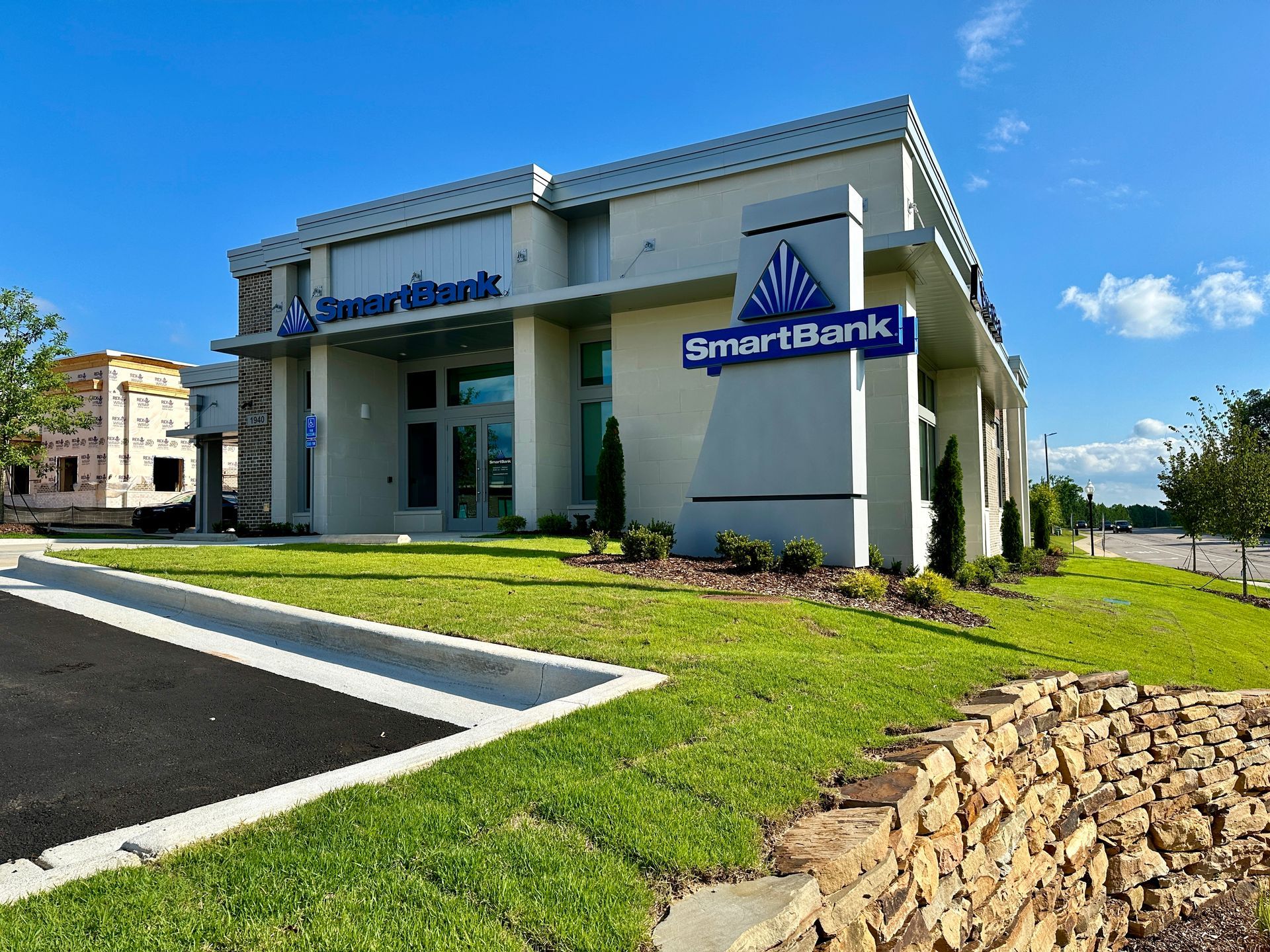 A smart bank building with a parking lot in front of it.