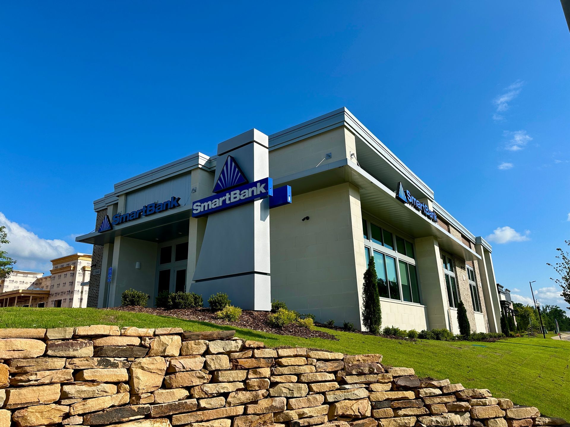 A large building with a stone wall in front of it.