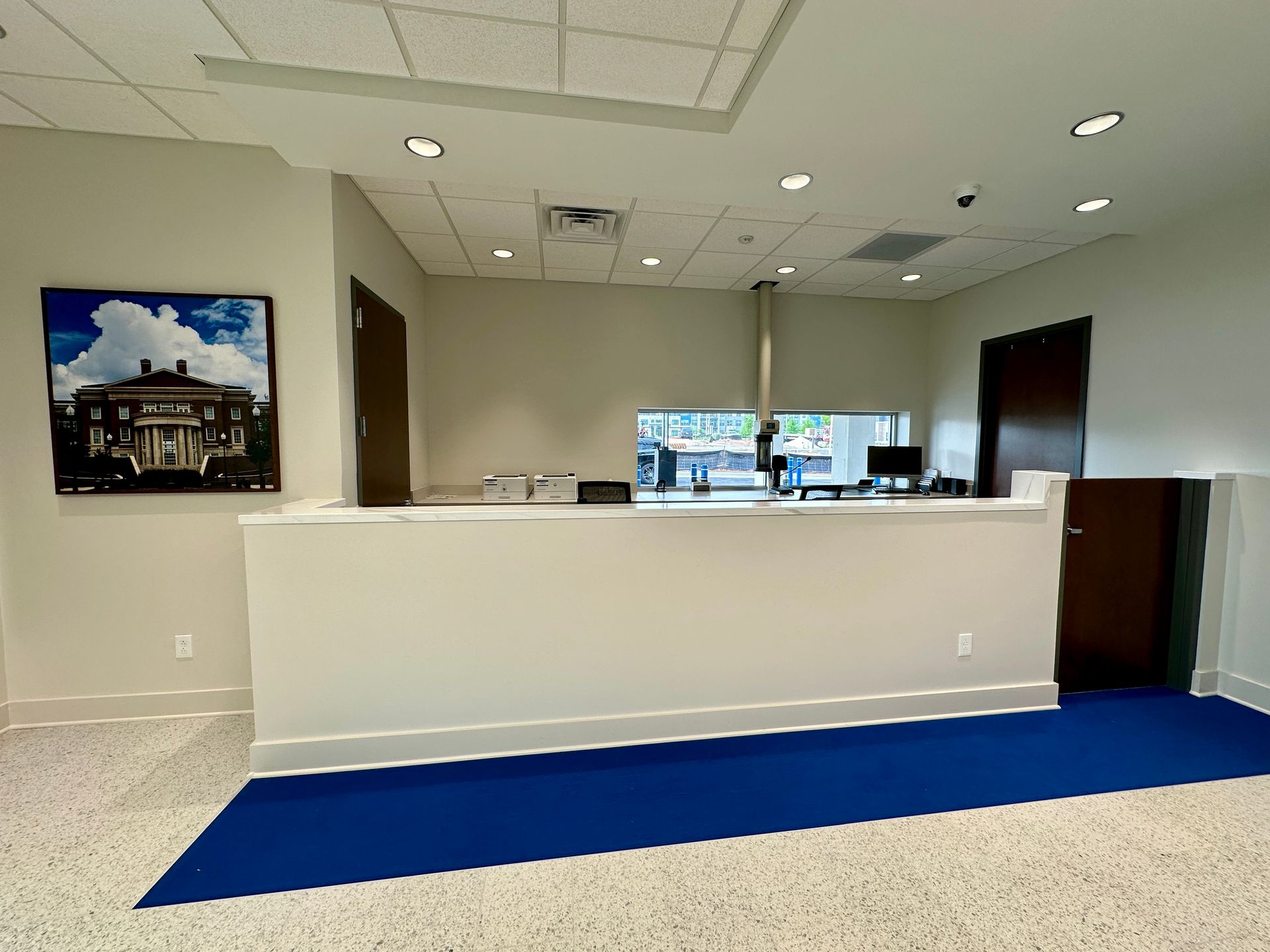A large white counter in a room with a blue rug on the floor.