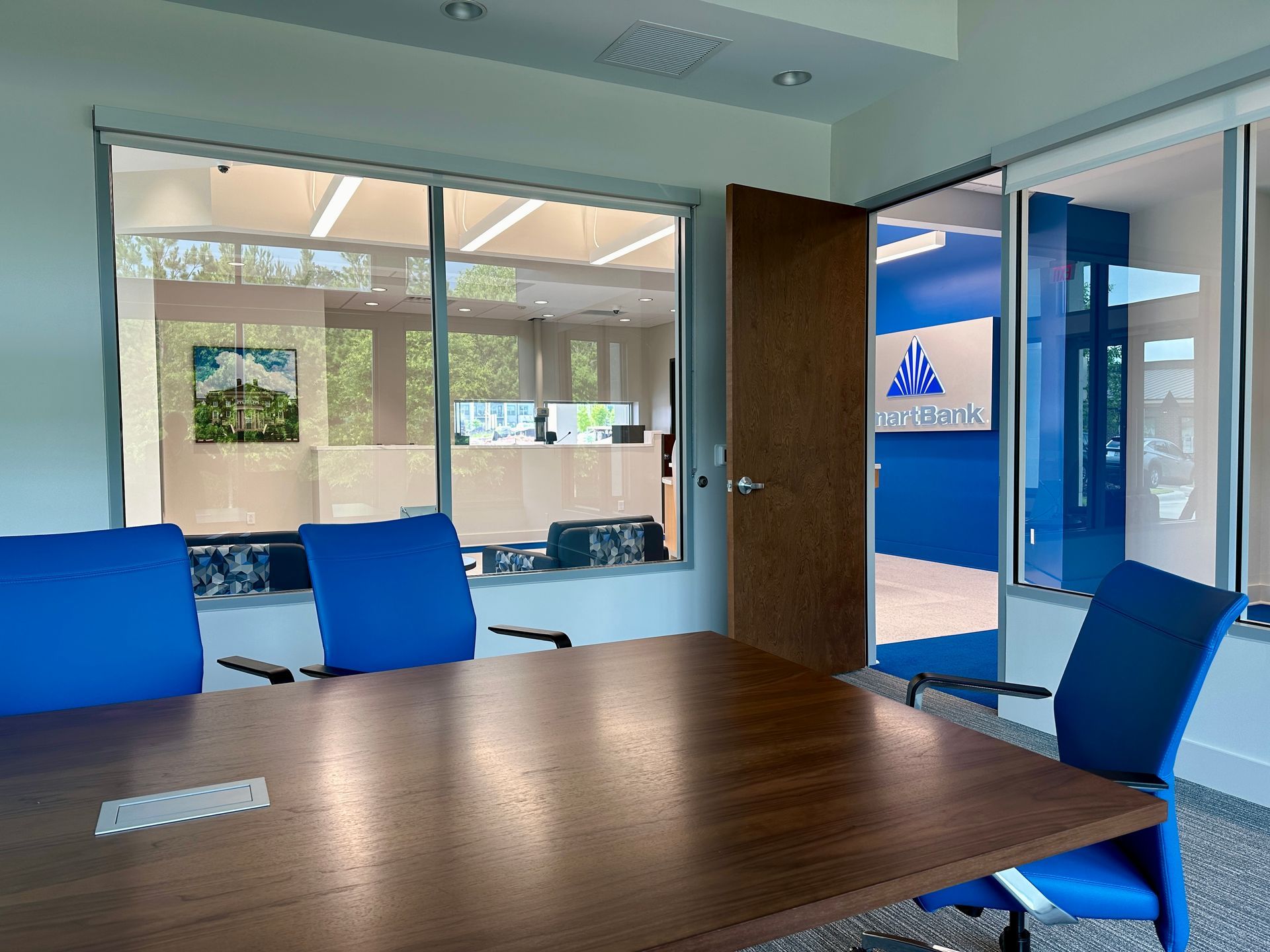 A conference room with a wooden table and blue chairs.