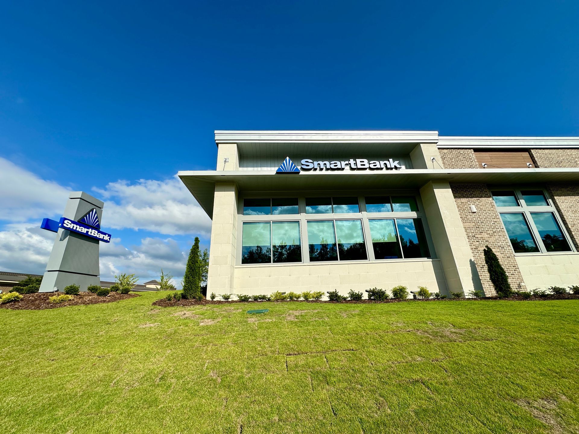 A large building with a lot of windows is sitting on top of a lush green field.