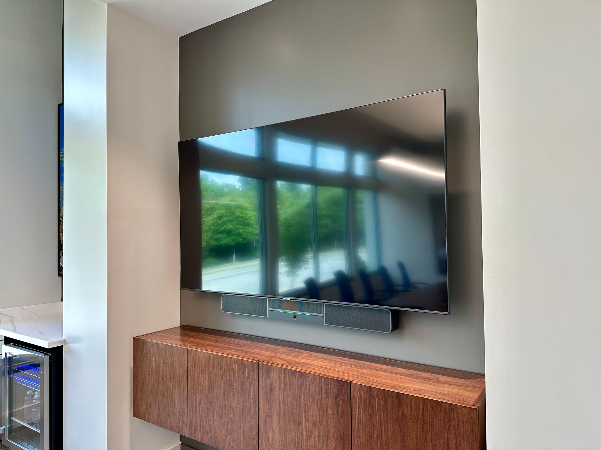 A large flat screen tv is mounted on a wall in a living room.