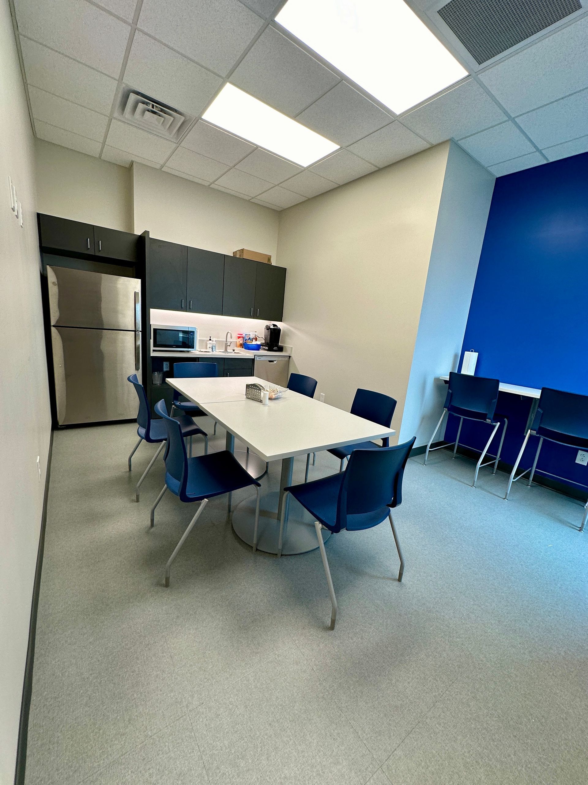 A kitchen with a table and chairs and a refrigerator.