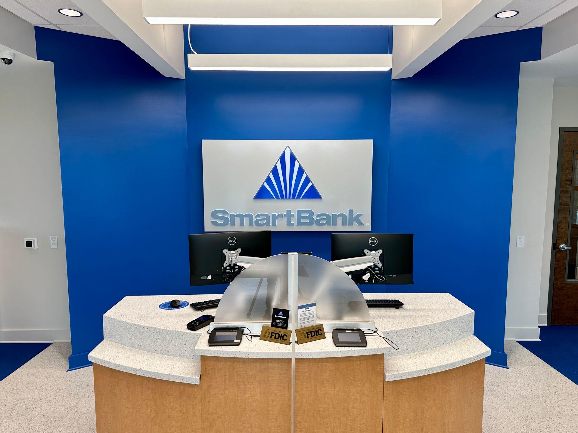 A smart bank lobby with a blue wall and a counter.