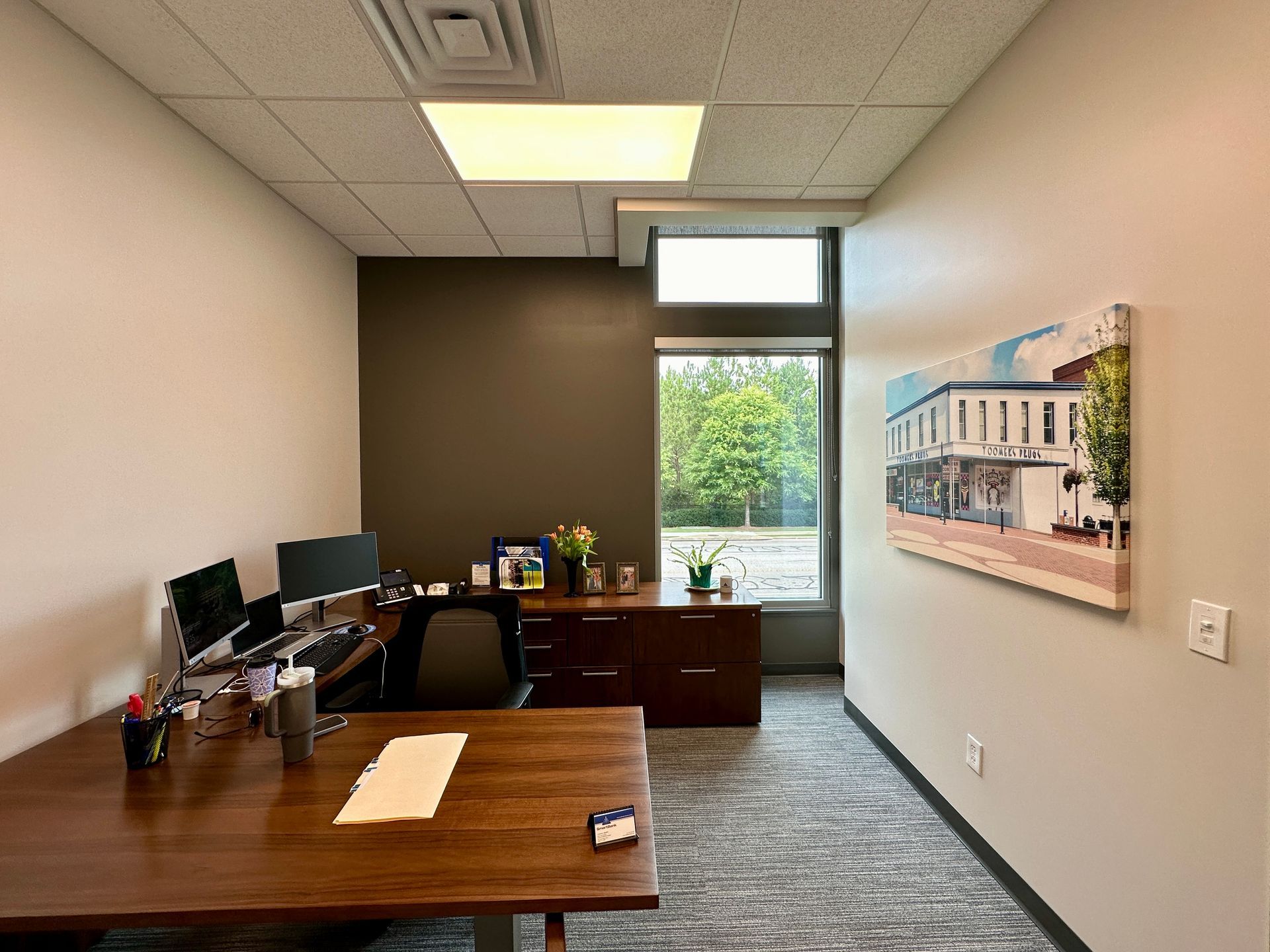 A small office with a desk and a picture on the wall.