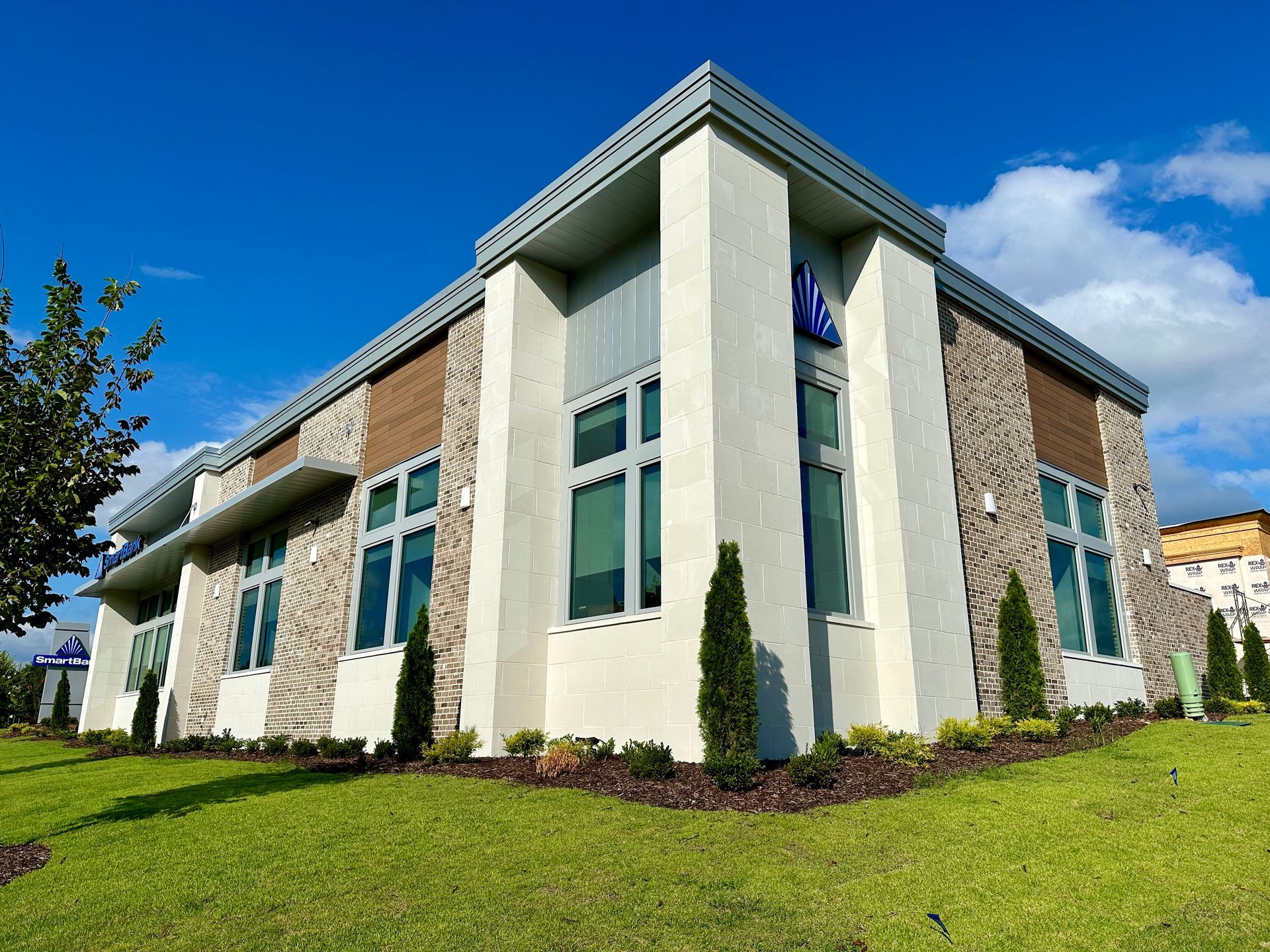 A large building with a lot of windows is sitting on top of a lush green field.