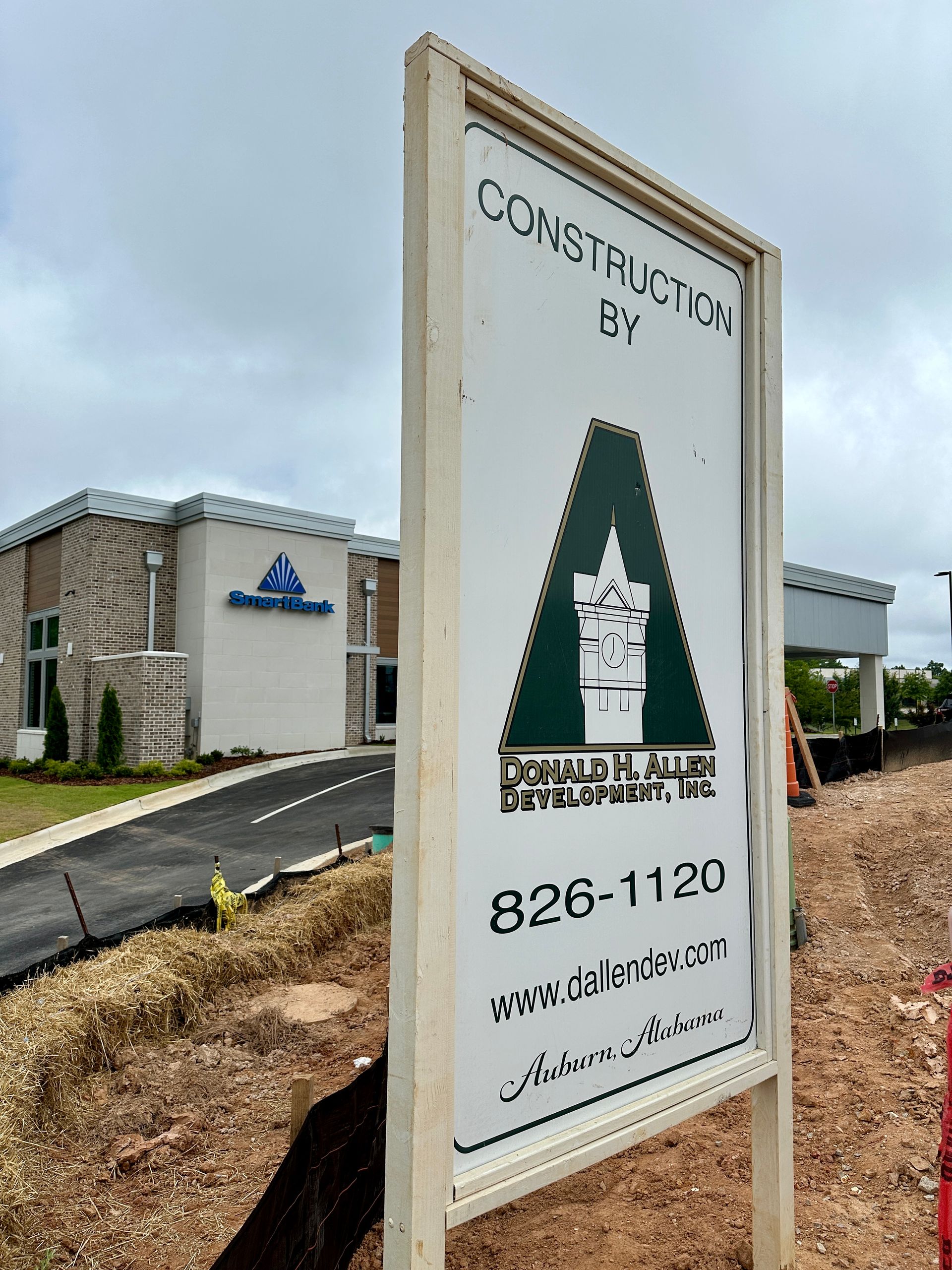 A sign for a construction company is sitting in front of a building.