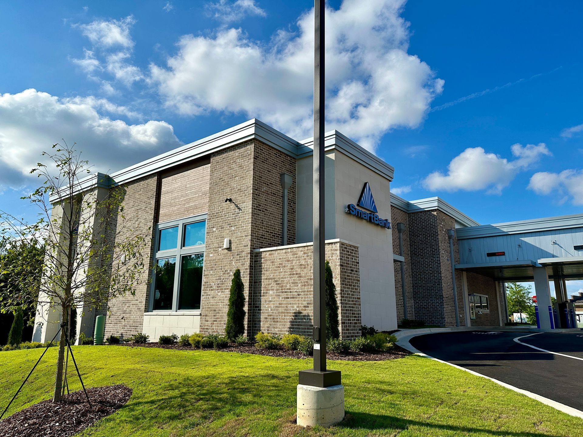 A large building with a lot of windows and a flag pole in front of it.