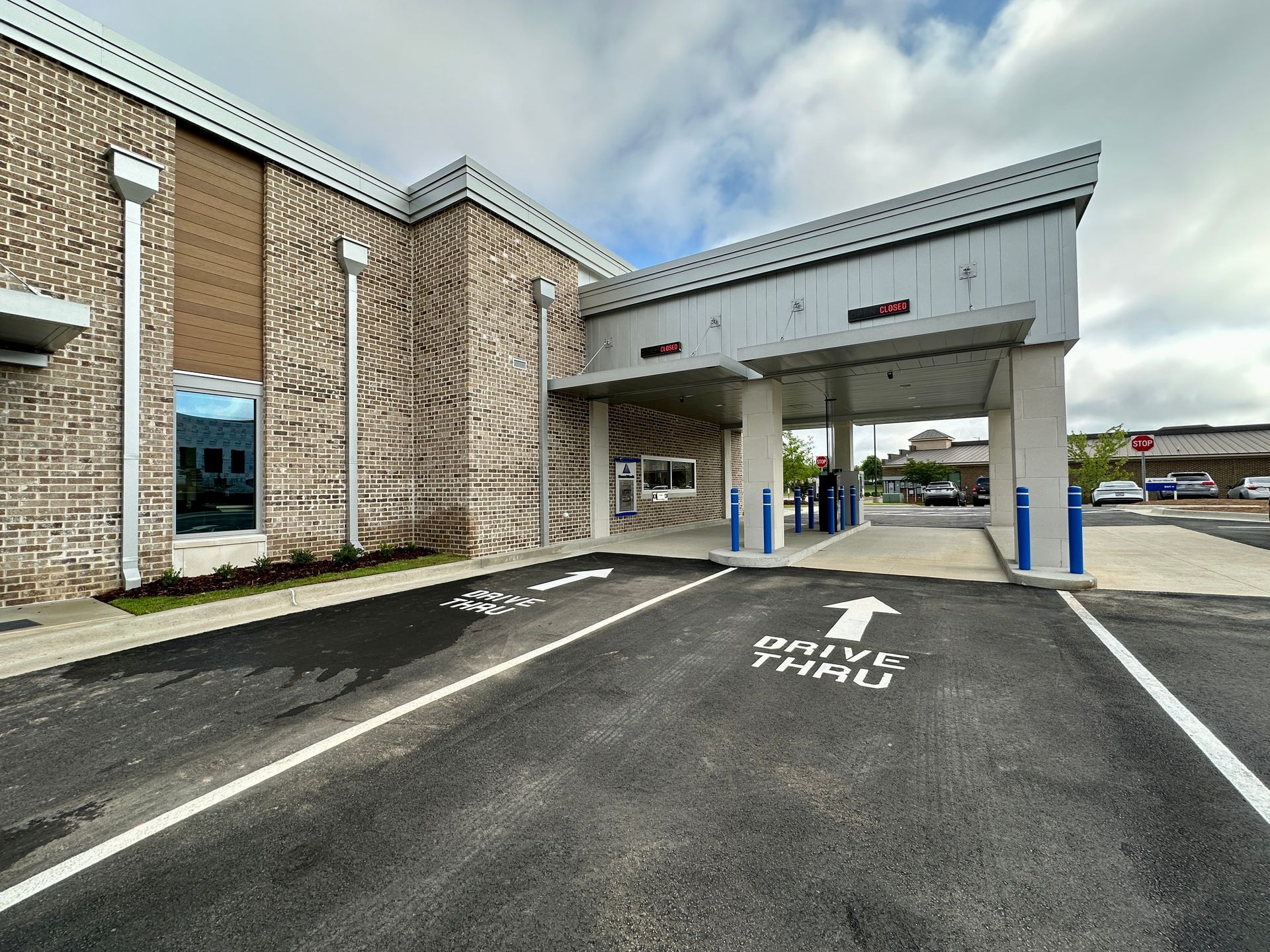 A large brick building with a parking lot in front of it.