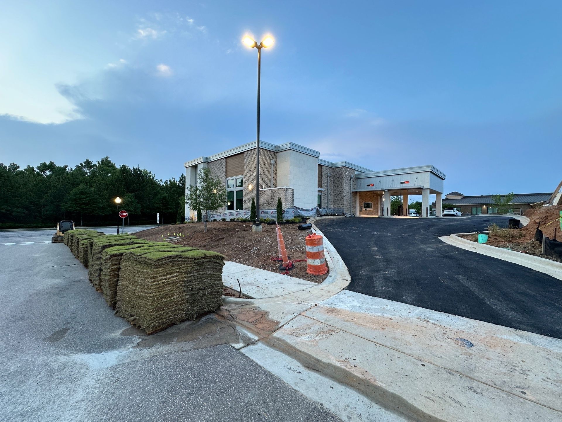 A building under construction with a lot of grass in front of it.