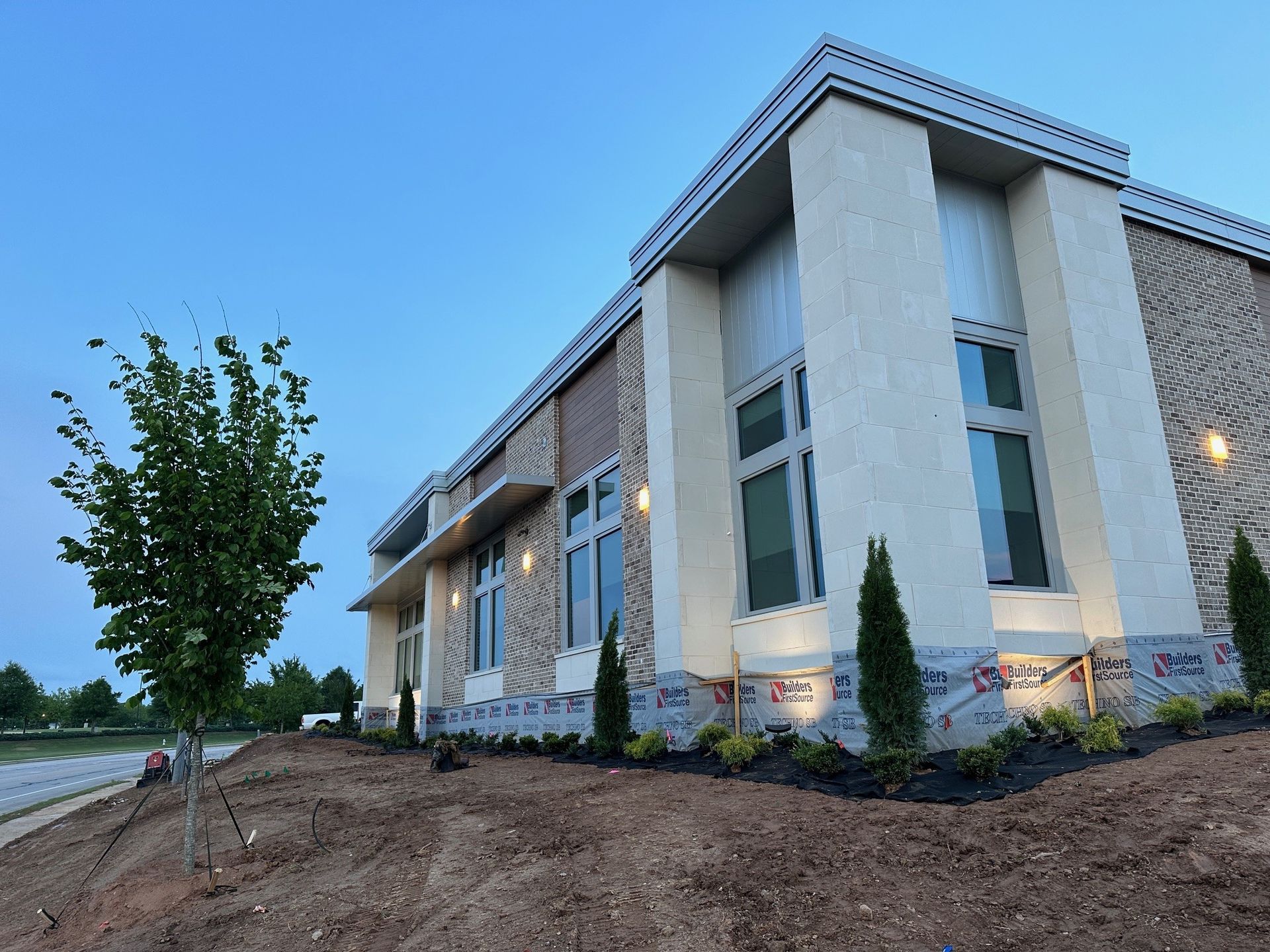 A large building with a lot of windows and a tree in front of it