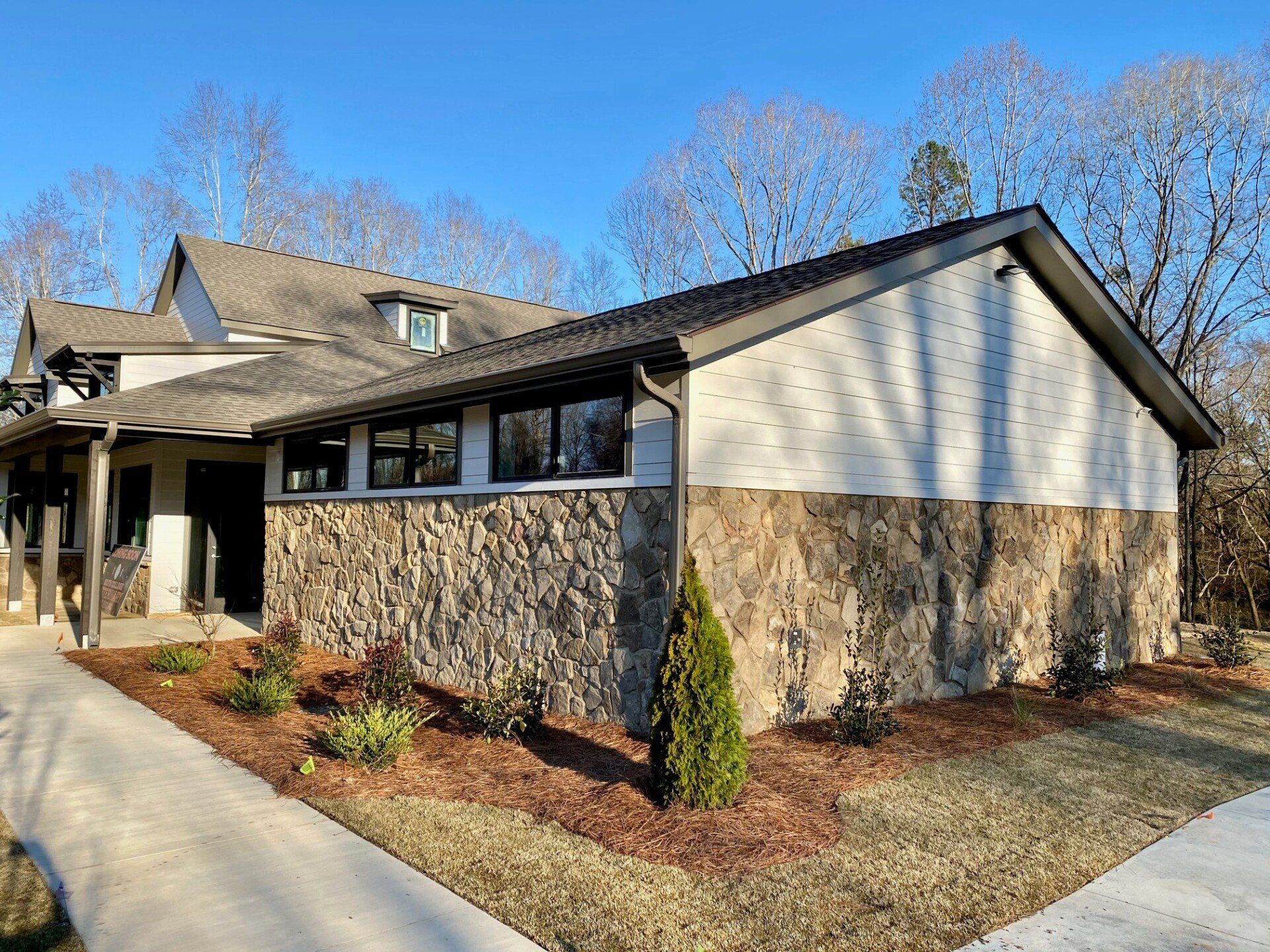 A large house with a lot of windows and a stone wall.